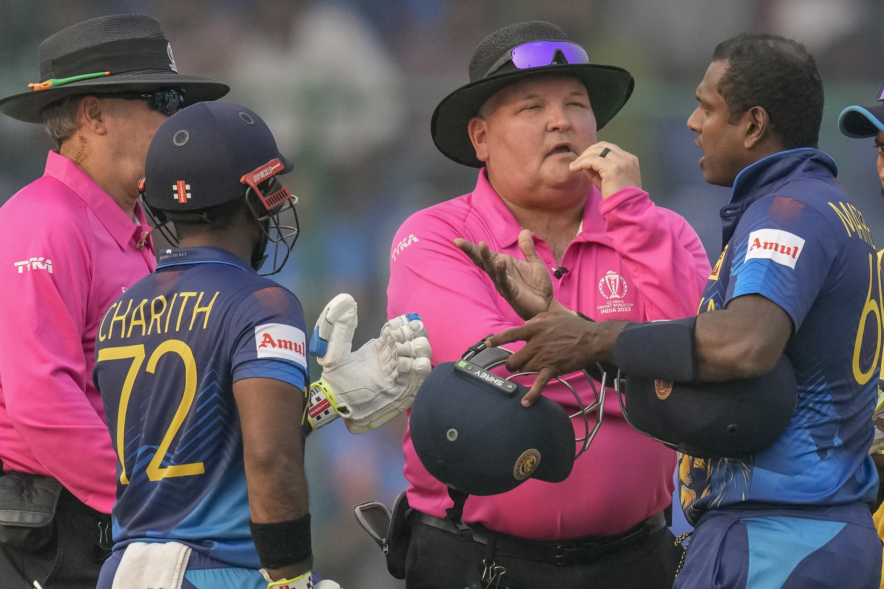 Sri Lanka's Angelo Mathews, right, talks to umpires after he was declared timed out during the ICC Men's Cricket World Cup match between Bangladesh and Sri Lanka in New Delhi, India, Monday, Nov. 6, 2023. Mathews who wasn’t ready to face his first ball within the stipulated two minutes became the first batter to be timed out in international cricket as the strap of his helmet appeared to be broken and he called for a replacement helmet. (AP Photo/Manish Swarup)