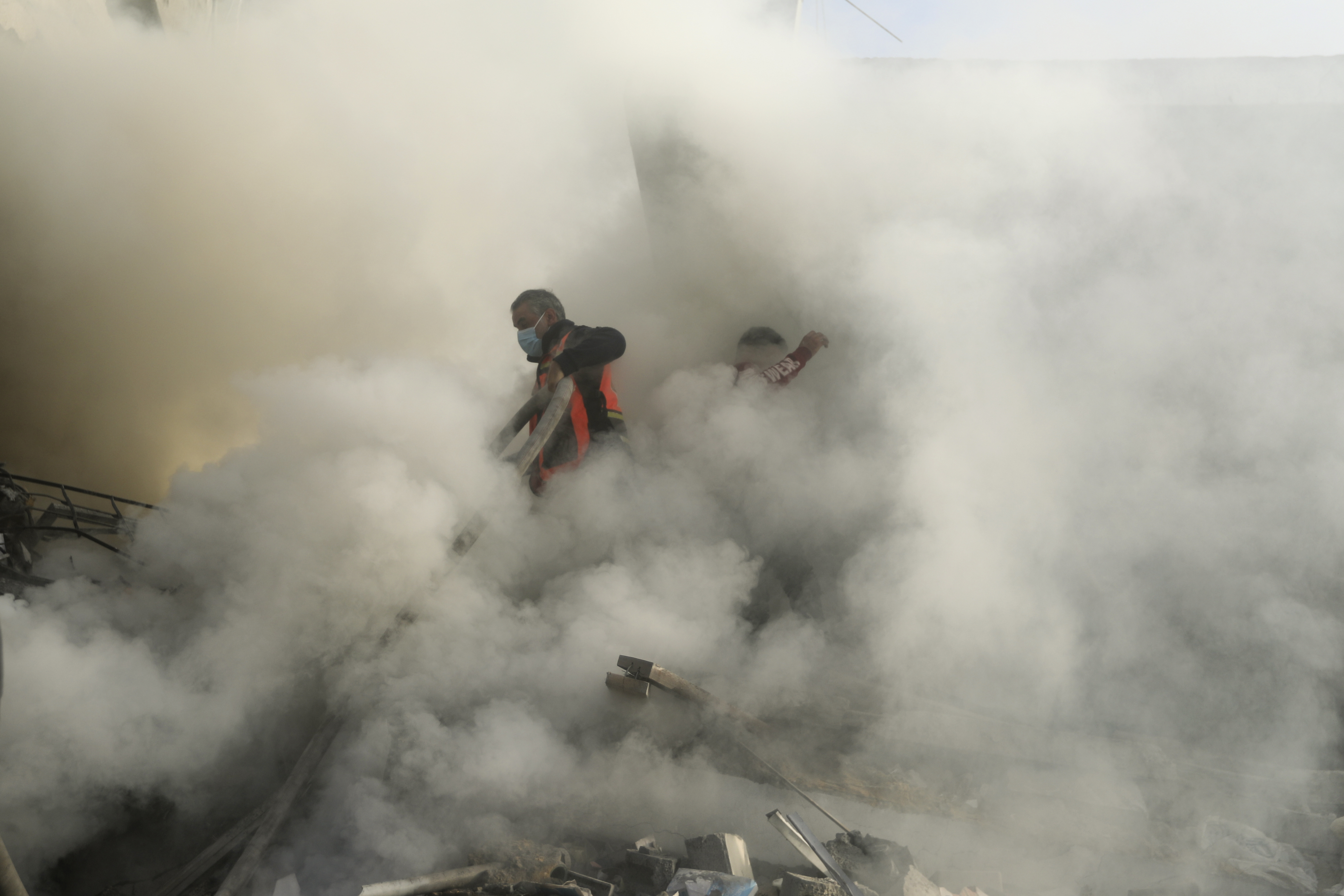 Palestinian firefighters extinguish fire caused by an Israeli airstrike in Khan Younis refugee camp, southern Gaza Strip.
