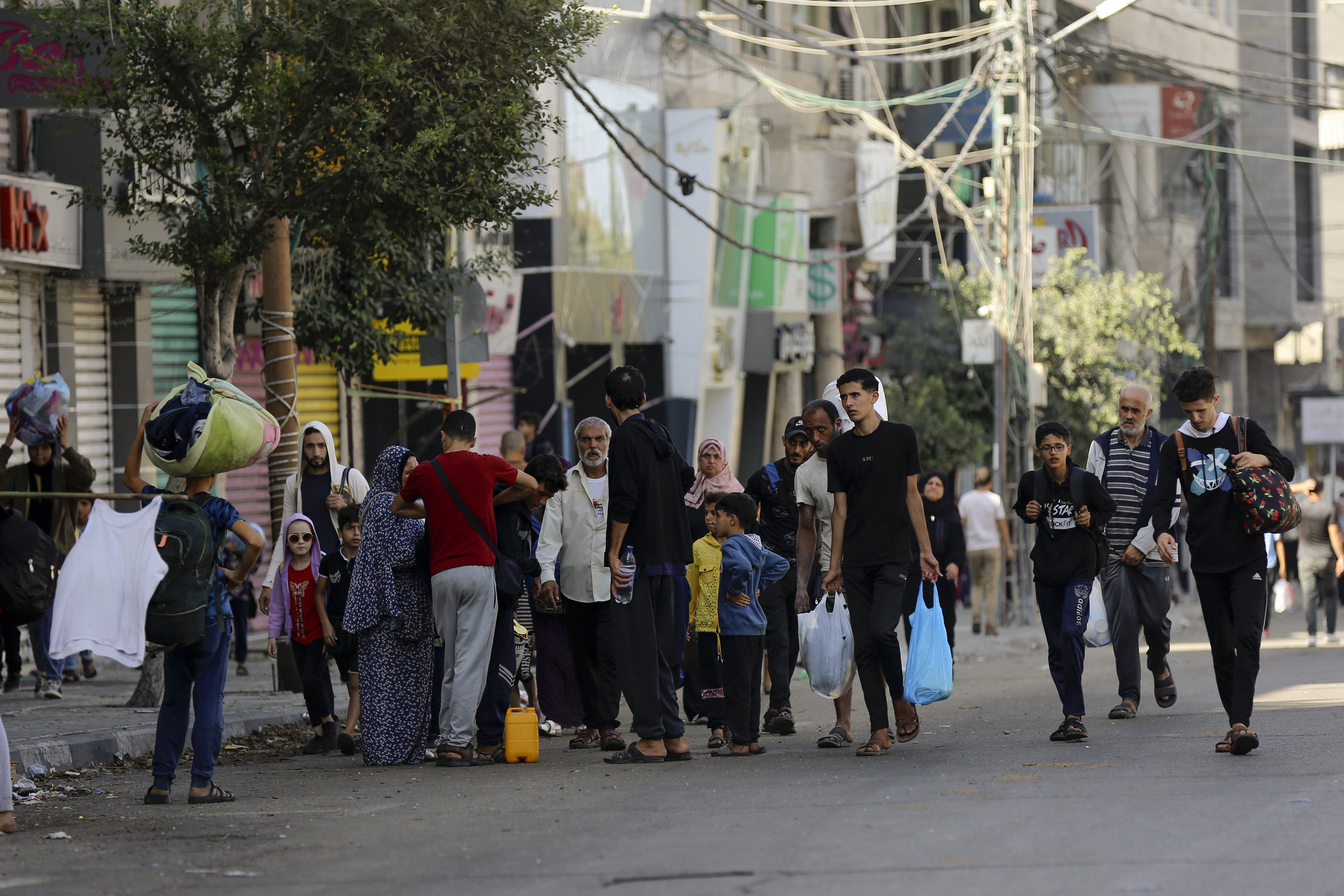 Palestinians walk in the al-Rimal neighbourhood, central Gaza City while fleeing to the southern Gaza Strip.