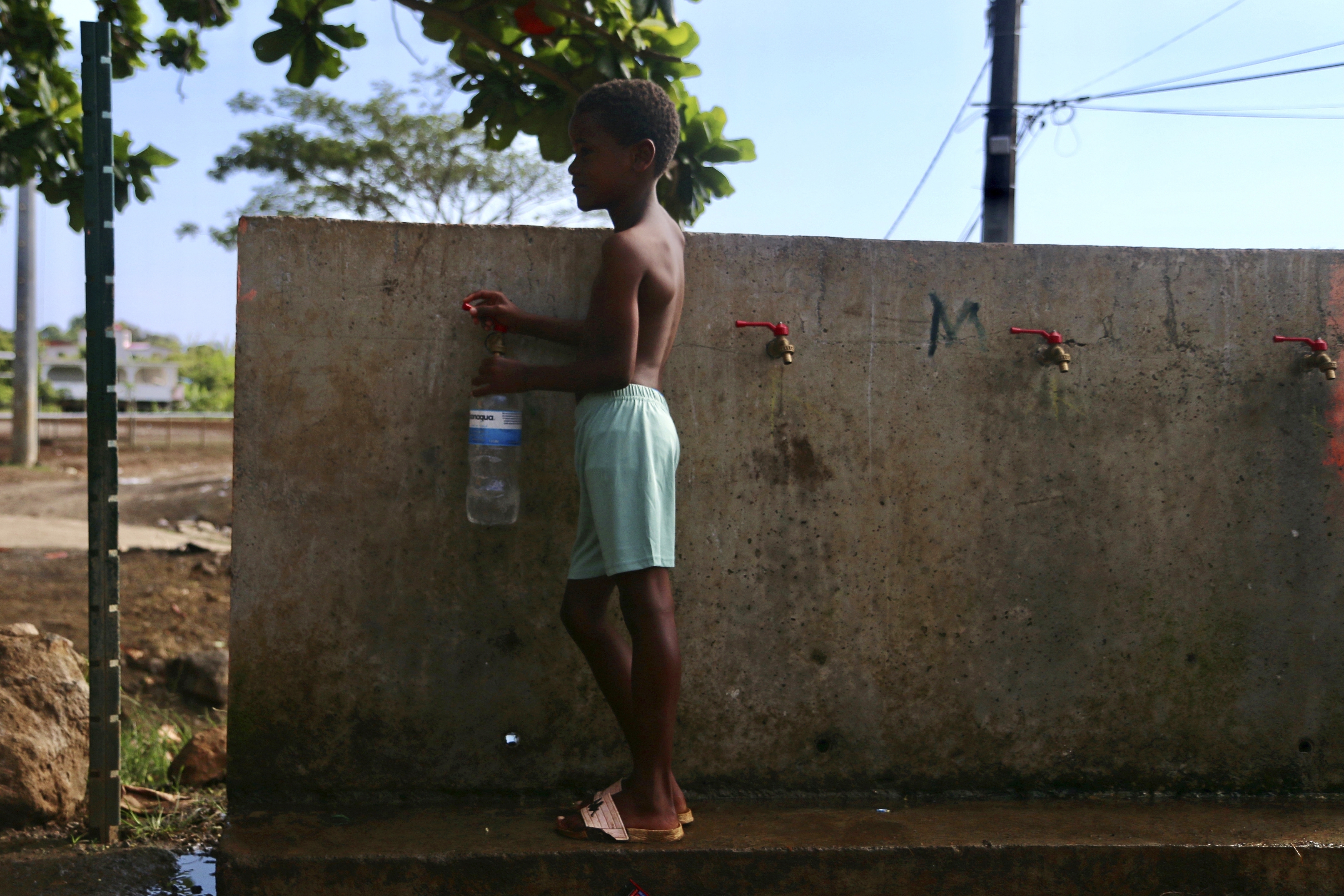 A boy fills up a bottle at the water fountain in M'tsamoudou, near Bandrele on the French Indian Ocean territory of Mayotte.