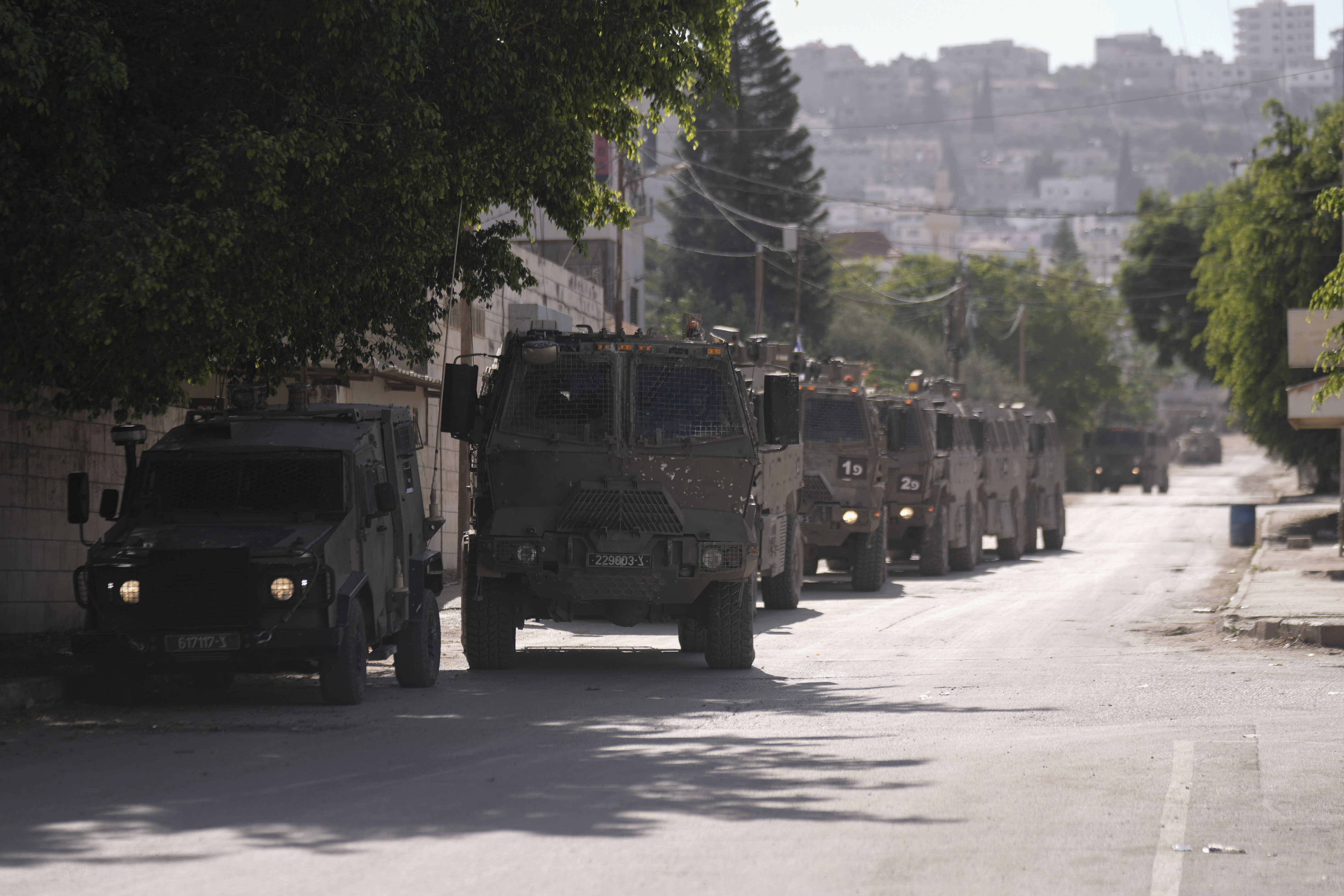 Israeli military convoy enters the Palestinian refugee camp in Jenin, the West Bank, Thursday.