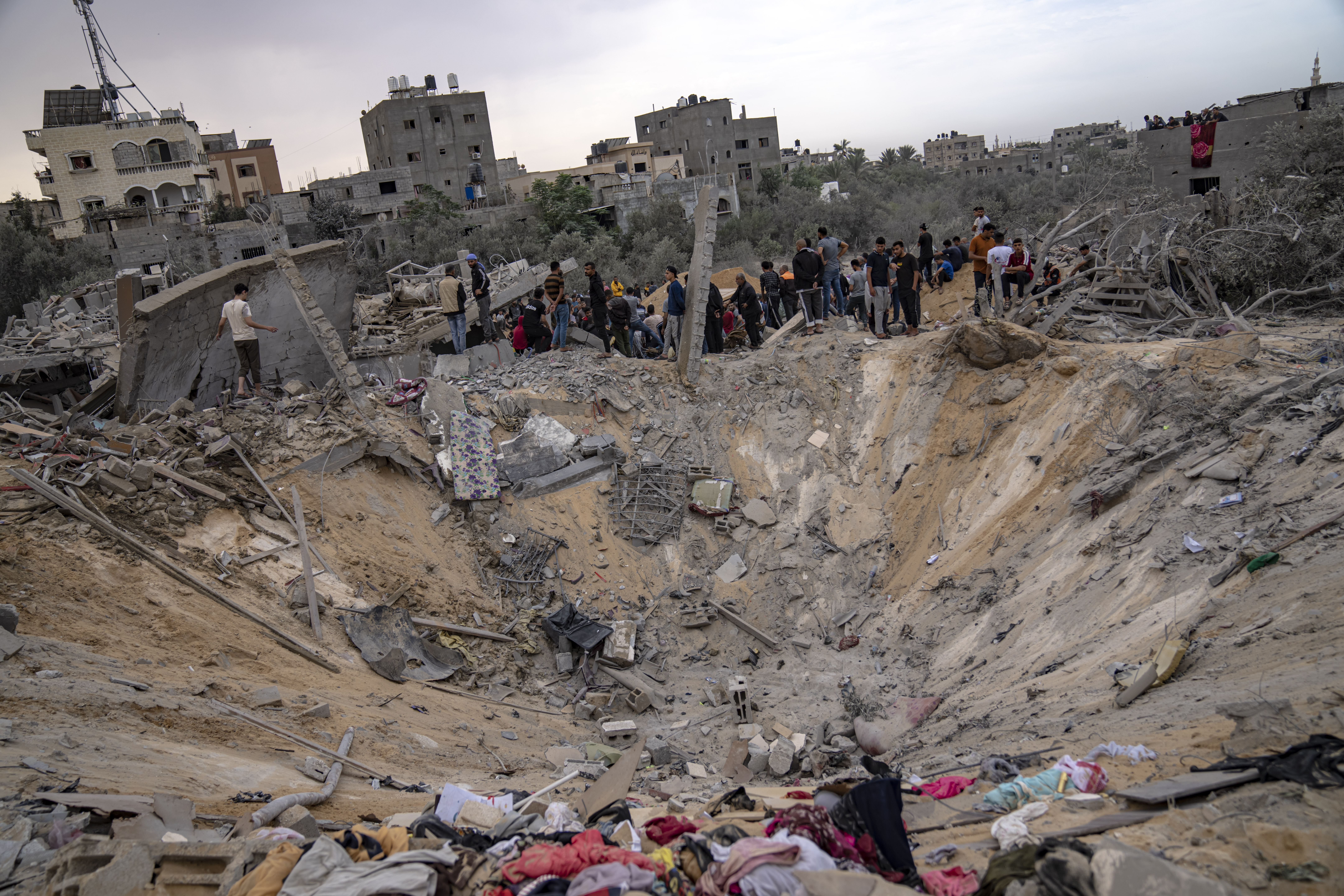 Belongings can be seen strewn around a crater in Khan Younis on Sunday