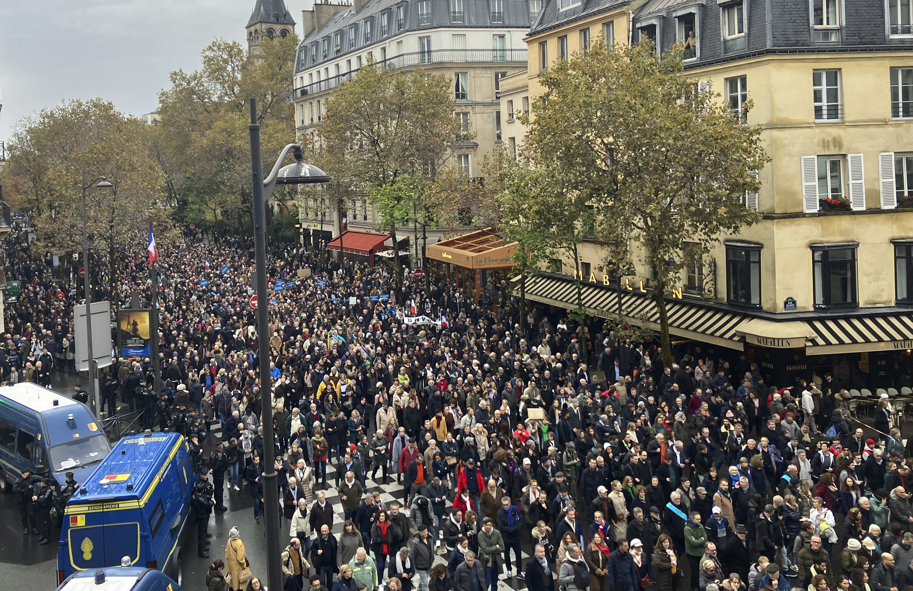 A large crowd of people marching along a street on Paris