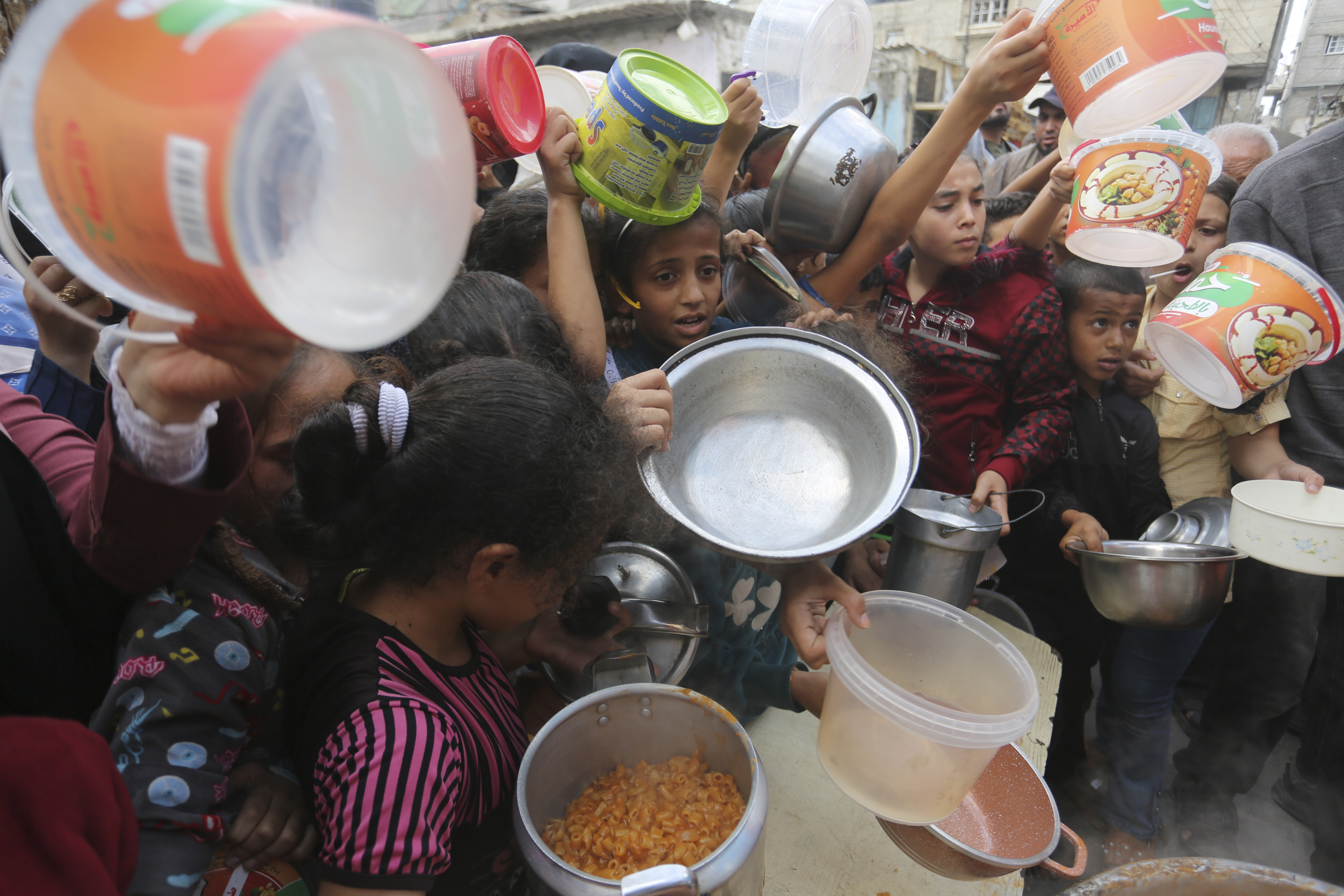 Palestinians line up for food during the ongoing Israeli bombardment of the Gaza Strip in Rafah on Monday