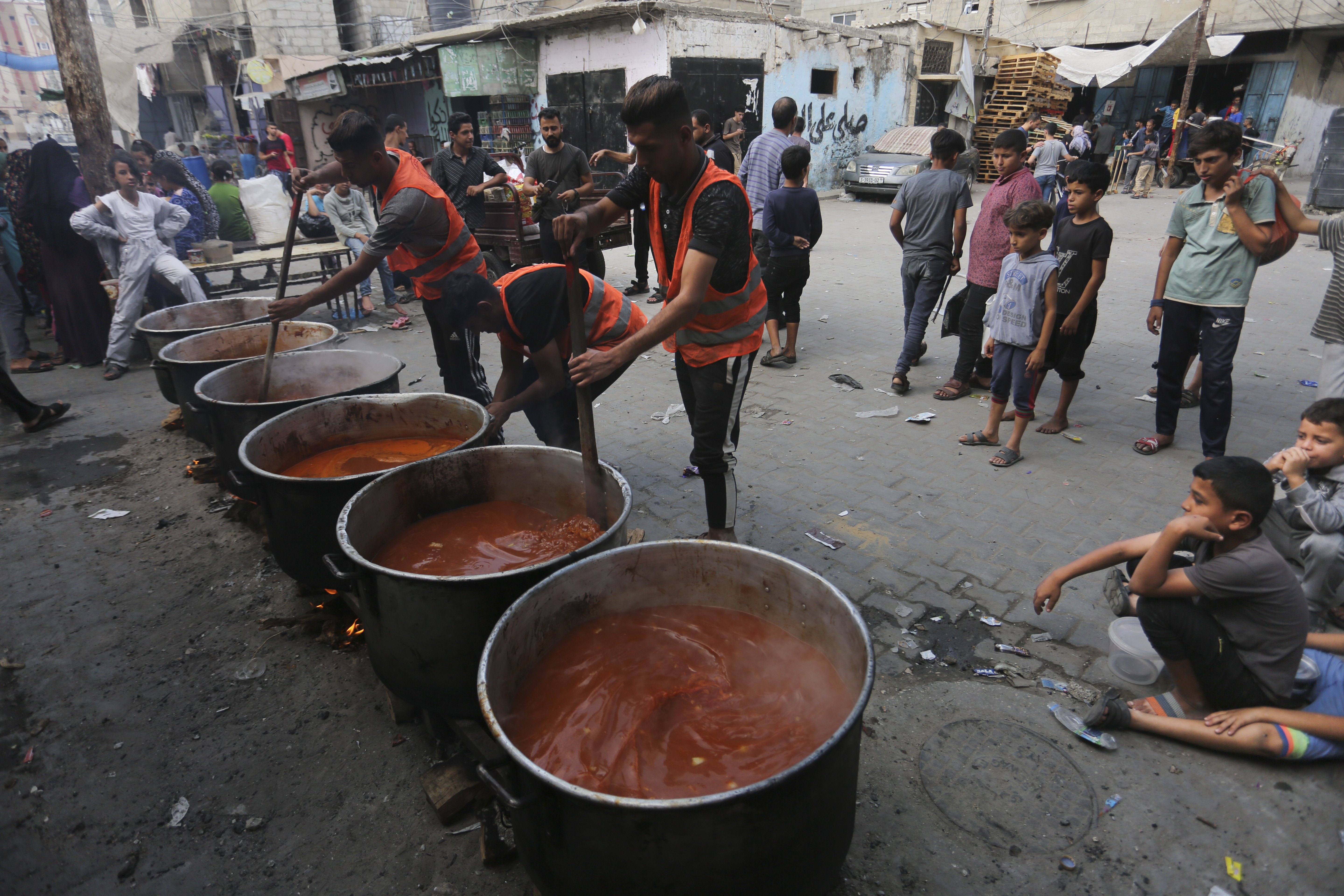 Palestinians cook during the ongoing Israeli bombardment of the Gaza Strip in Rafah on Monday