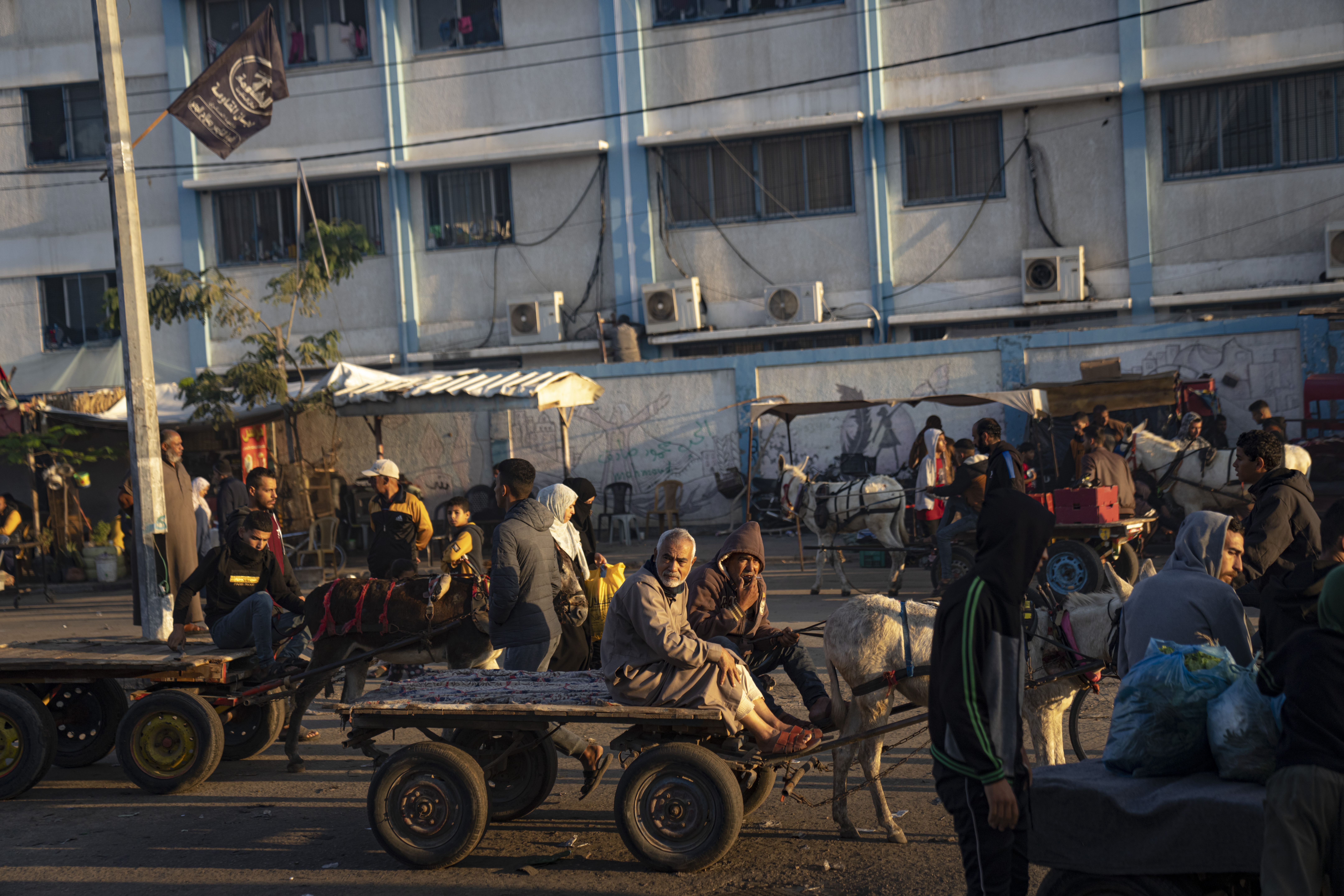 Palestinians ride donkey carts during the ongoing Israeli bombardment of the Gaza Strip in Khan Younis on Friday