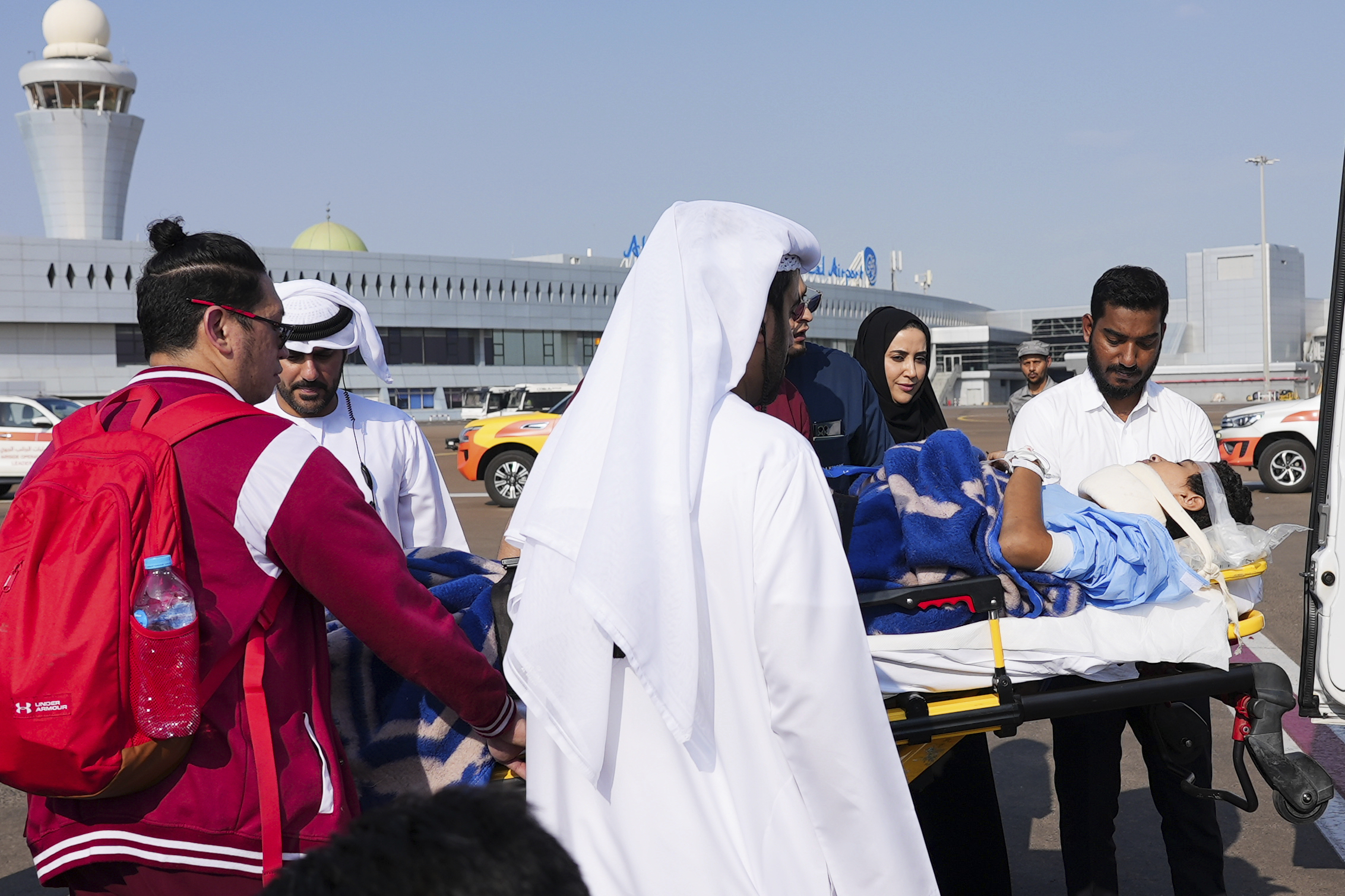 Medical personnel and officials move Mohammed Abu Tabikh, 14, who was wounded in the neck and spine during the Israel-Hamas war, from a plane to an ambulance on a stretcher in Abu Dhabi, United Arab Emirates