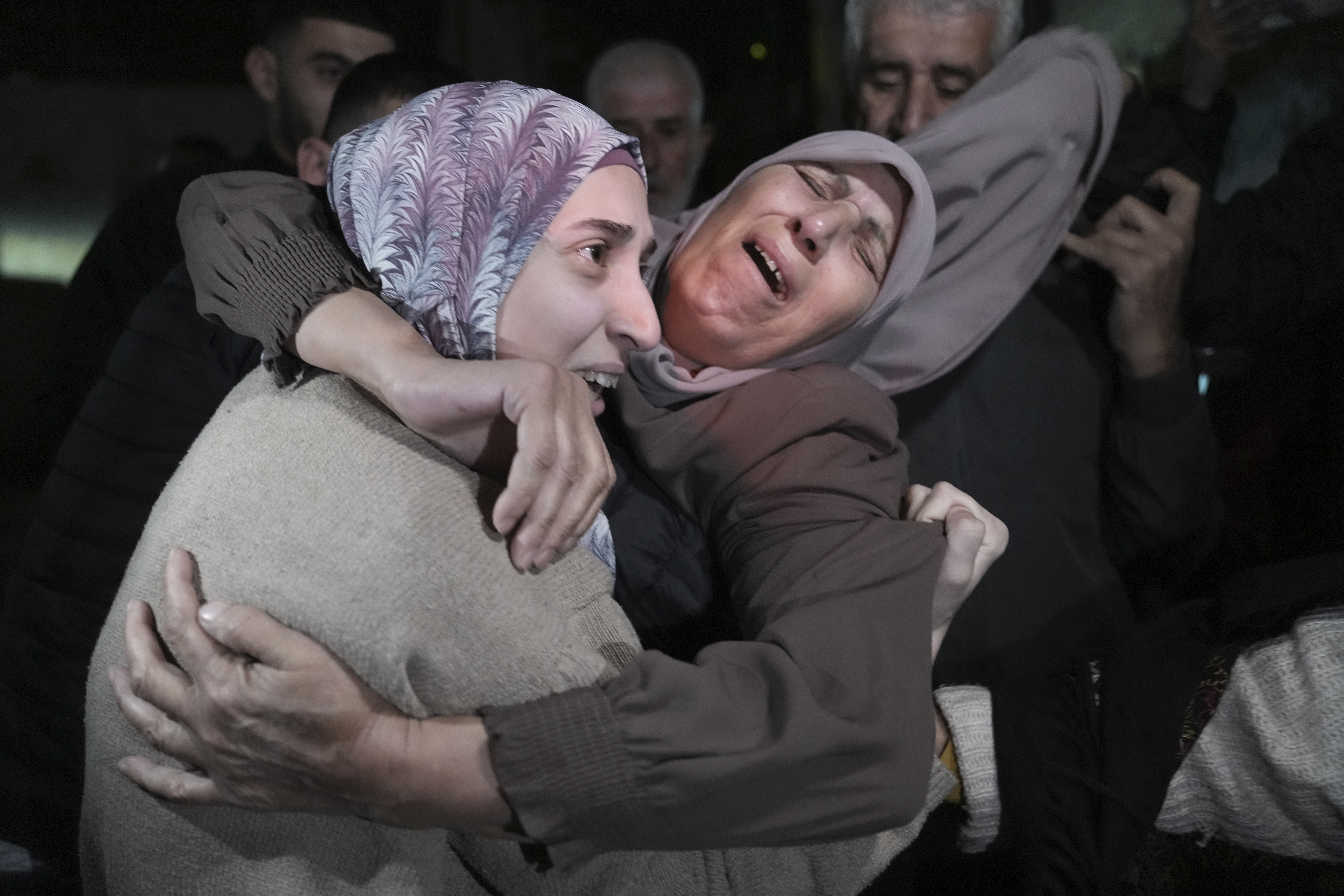 Shuruq Dwayat, left, a Palestinian prisoner released by Israel, is hugged by relatives as she arrives home in the east Jerusalem neighborhood of Sur Bahar, early Sunday Nov. 26