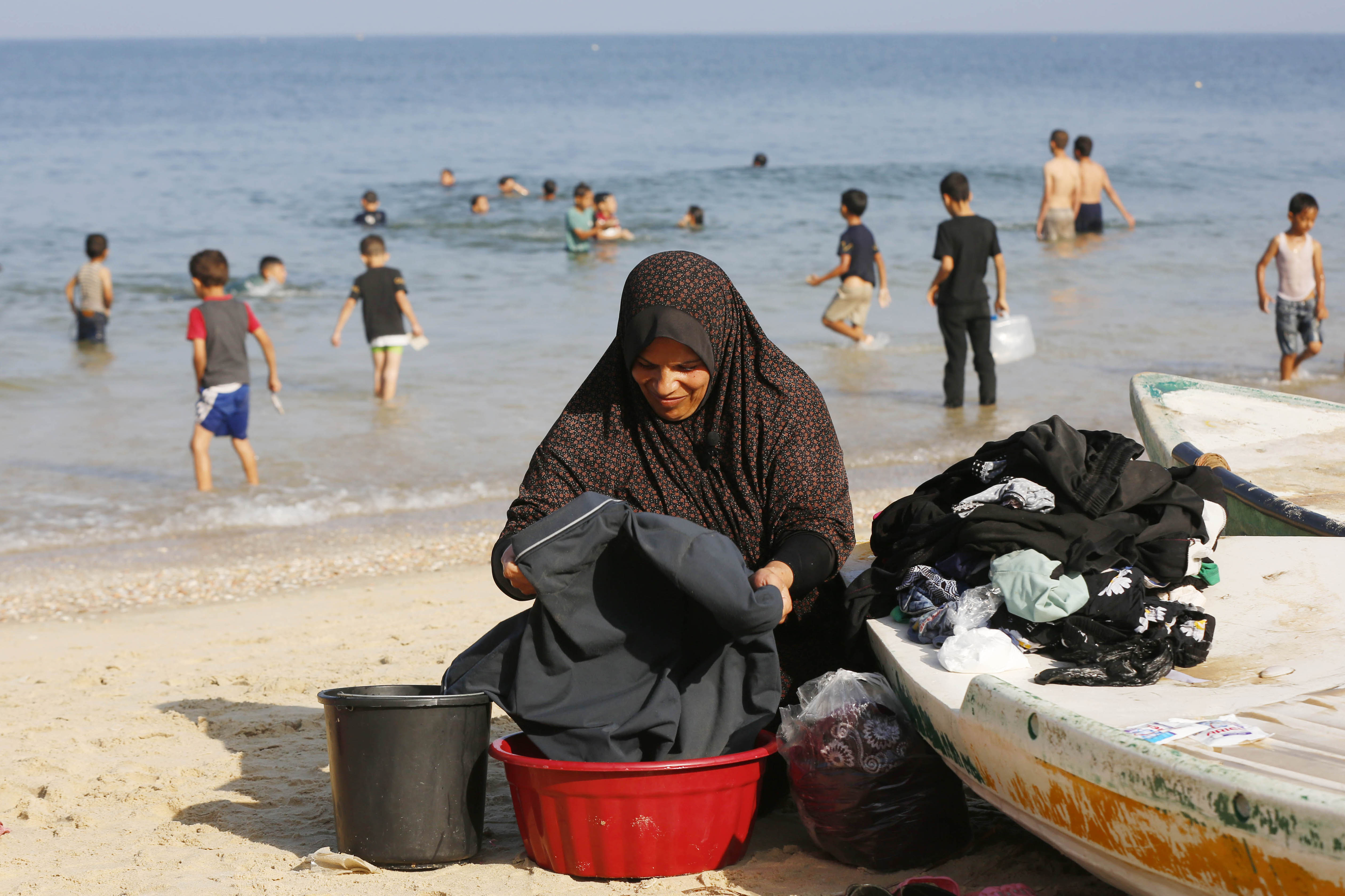 Palestinians using the sea to wash their clothes and bathe