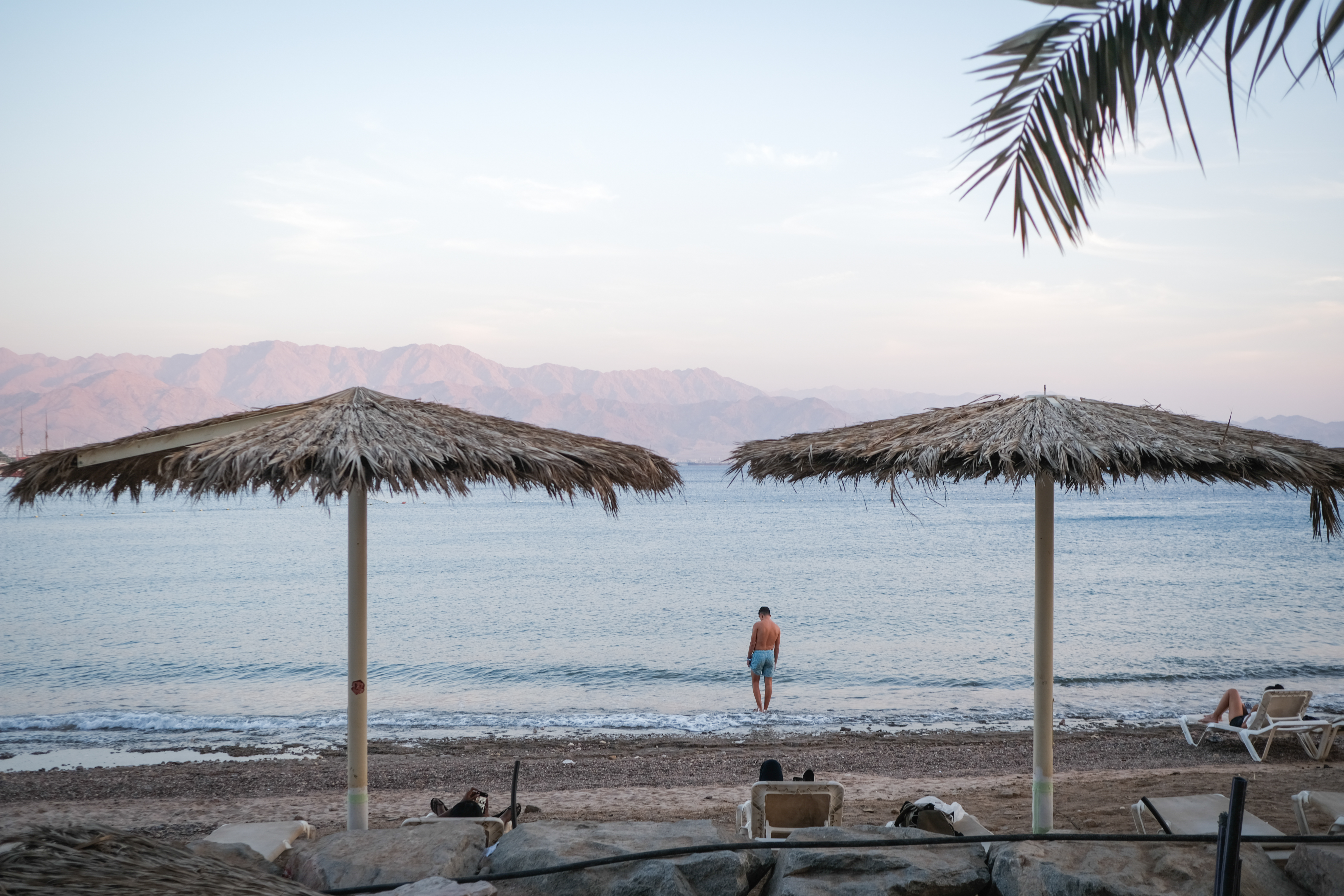 Man on the beach walking into water