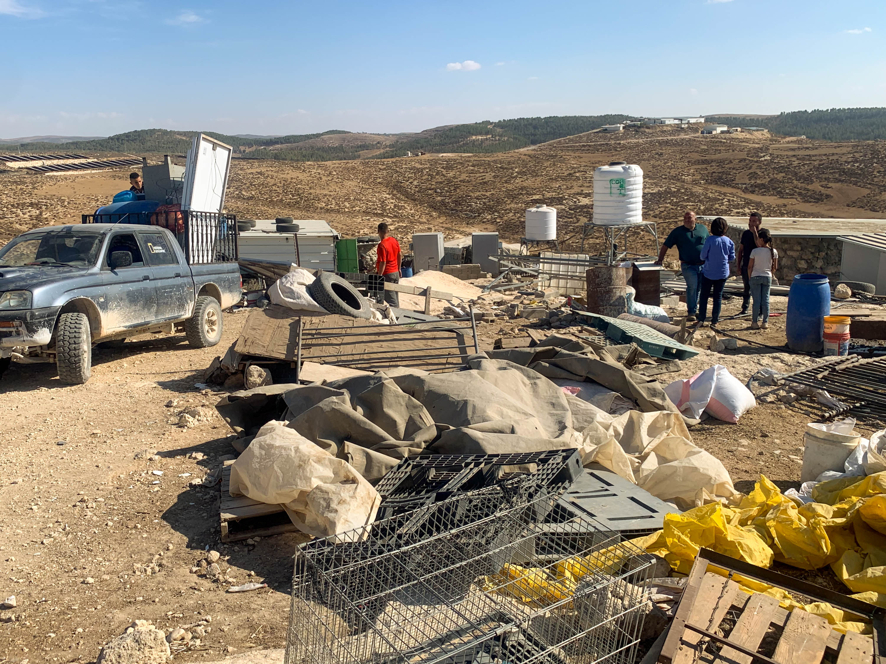 Zanouta packing with outpost in background [Steven Davidson/Al Jazeera]
