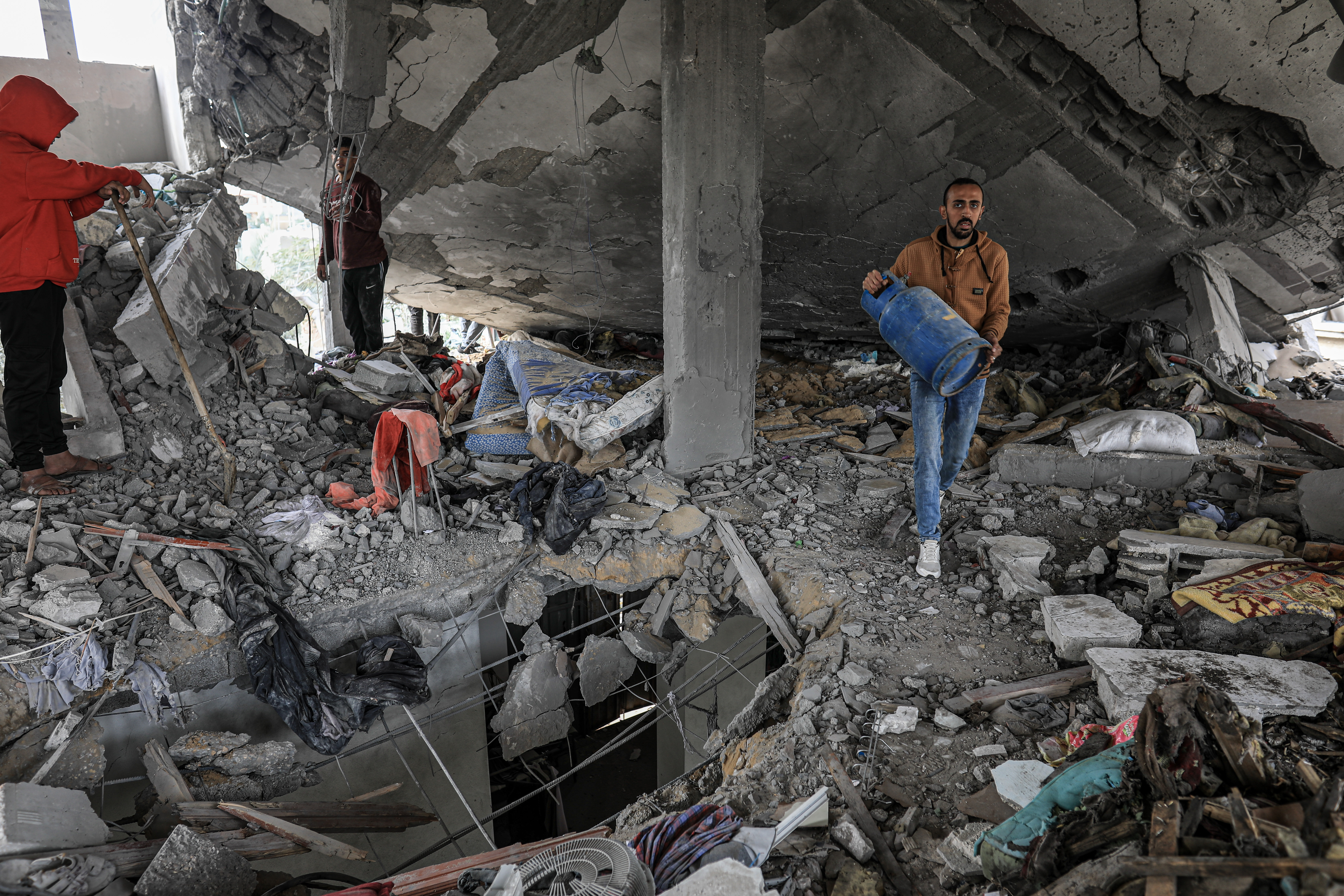 People pull out belongings from under the rubble