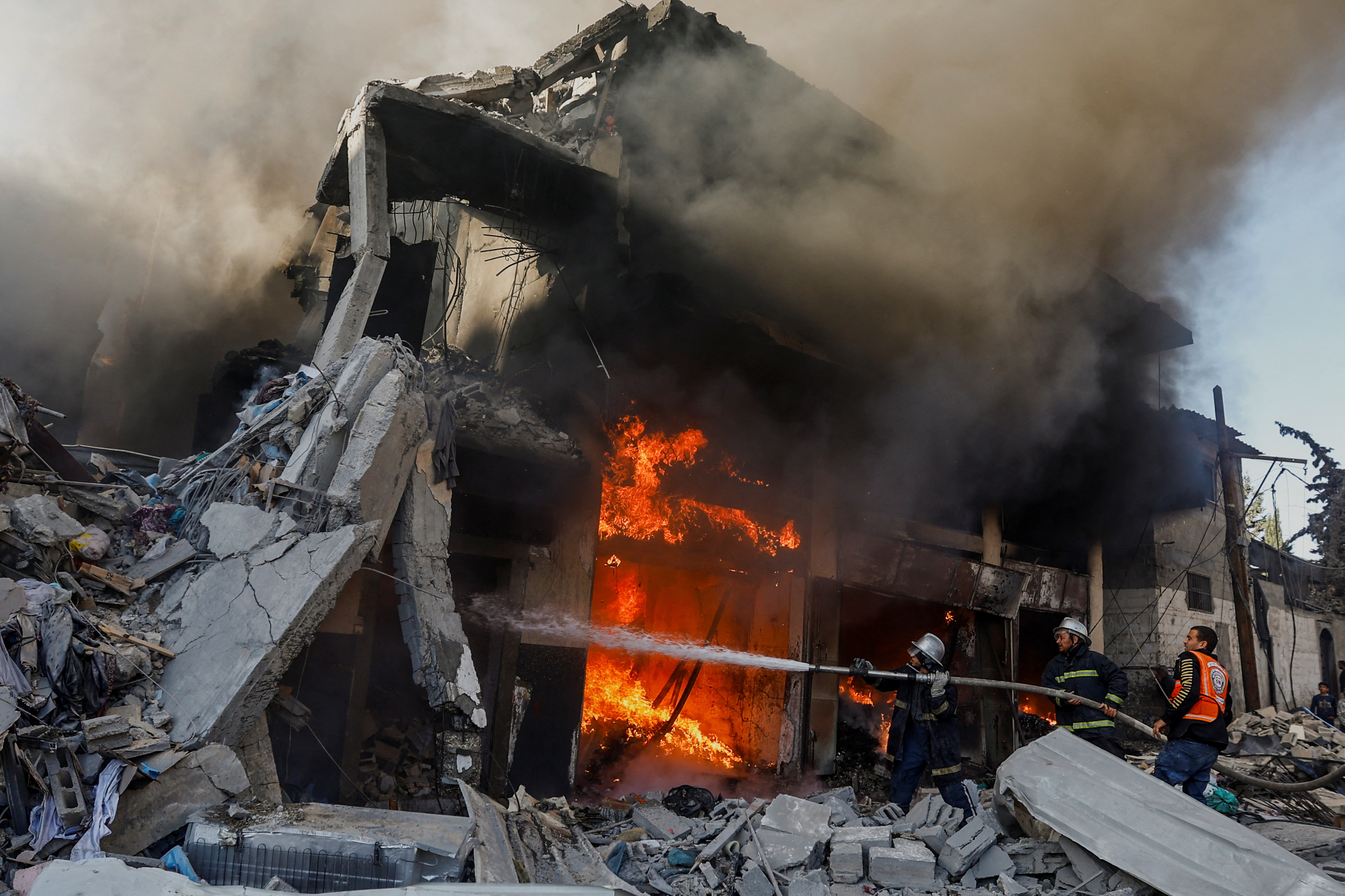 Palestinian firefighters work to extinguish a fire in a house after an Israeli strike, amid the ongoing conflict between Israel and Palestinian Islamist group Hamas, in Khan Younis in the southern Gaza Strip, December 9, 2023. REUTERS/Ibraheem Abu Mustafa