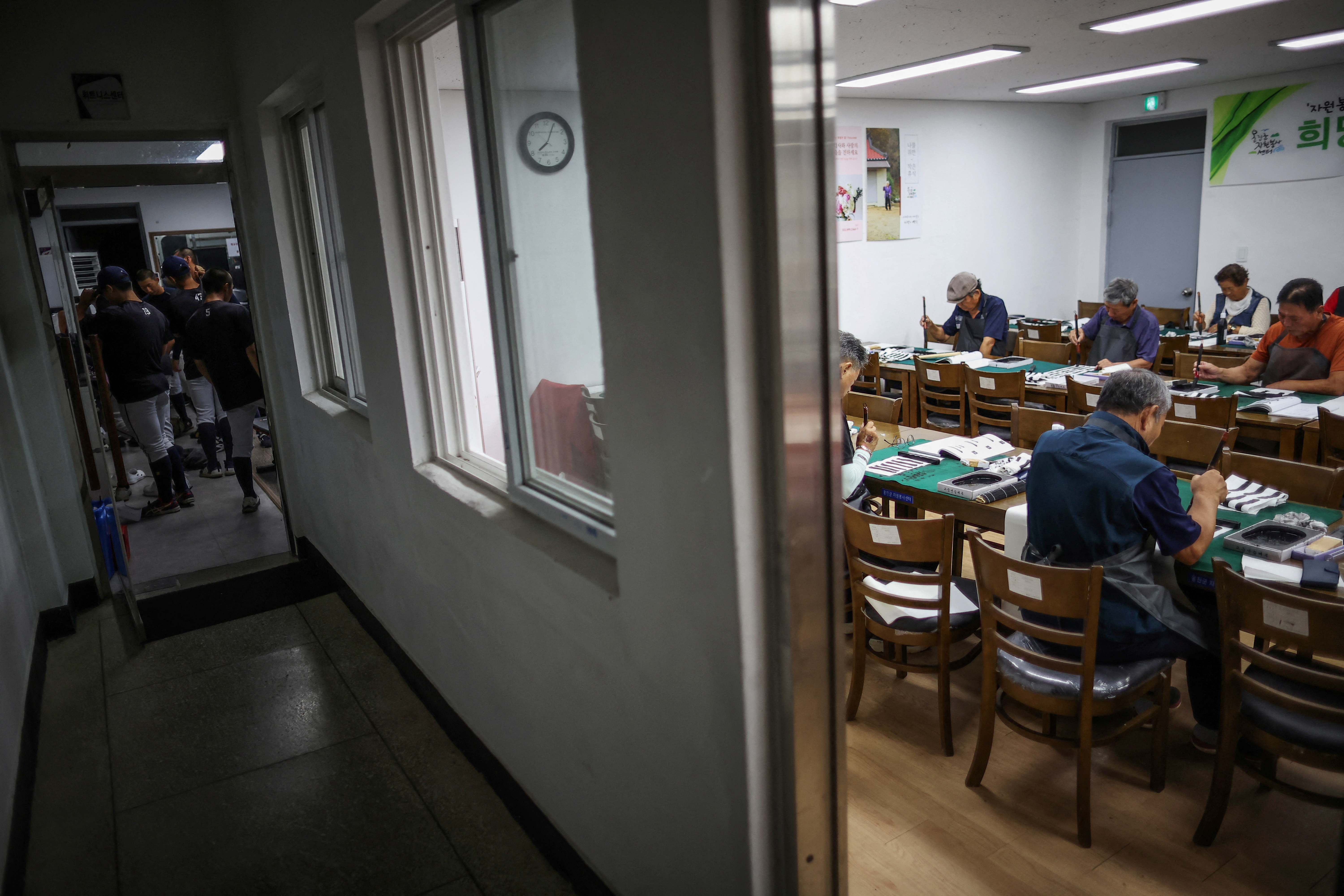 Members of the Deokjeok High School baseball team leave after a workout, as locals attend a calligraphy class, on Deokjeok island in Incheon, South Korea.