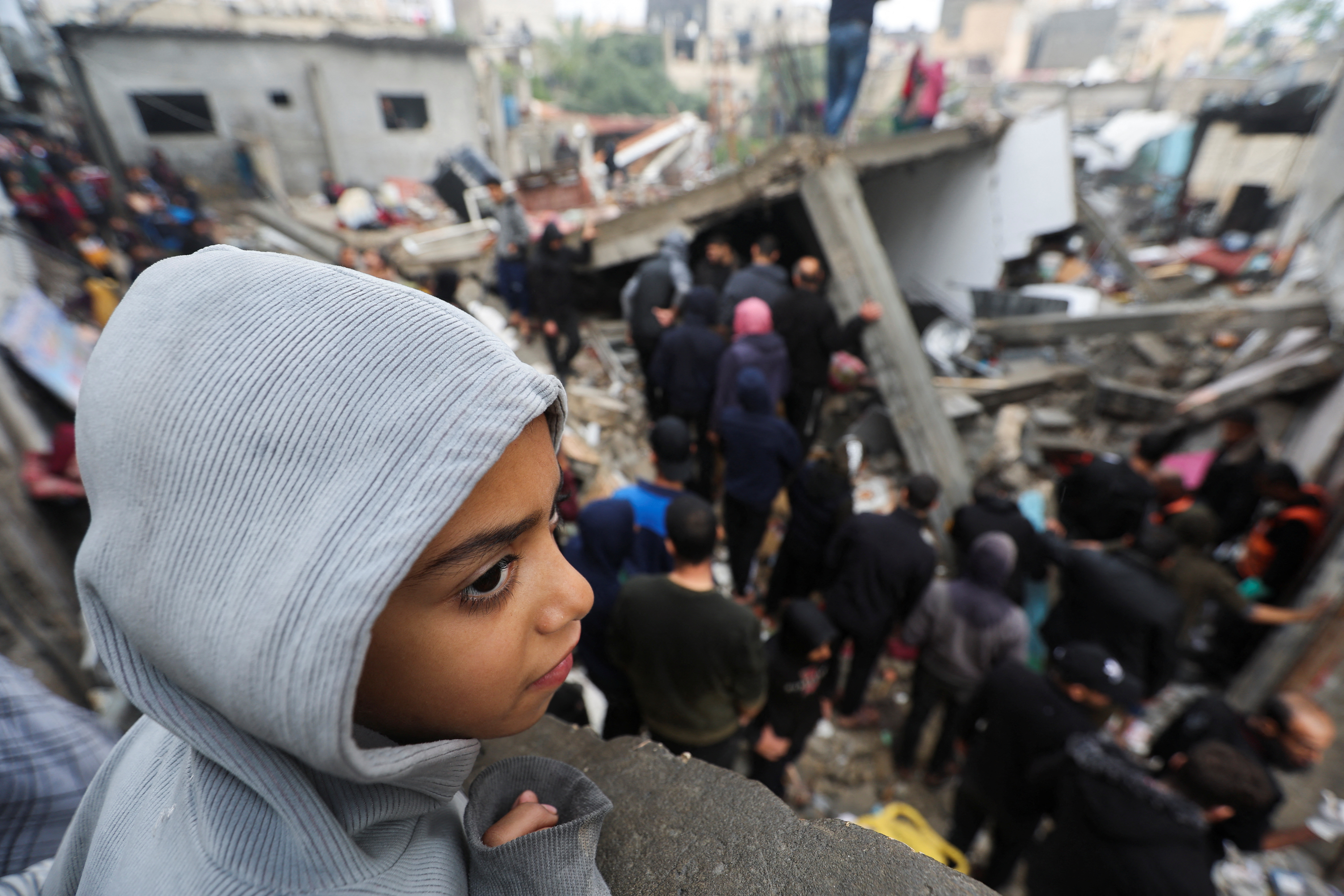 A child looks on as people gather after an air strike on Gaza