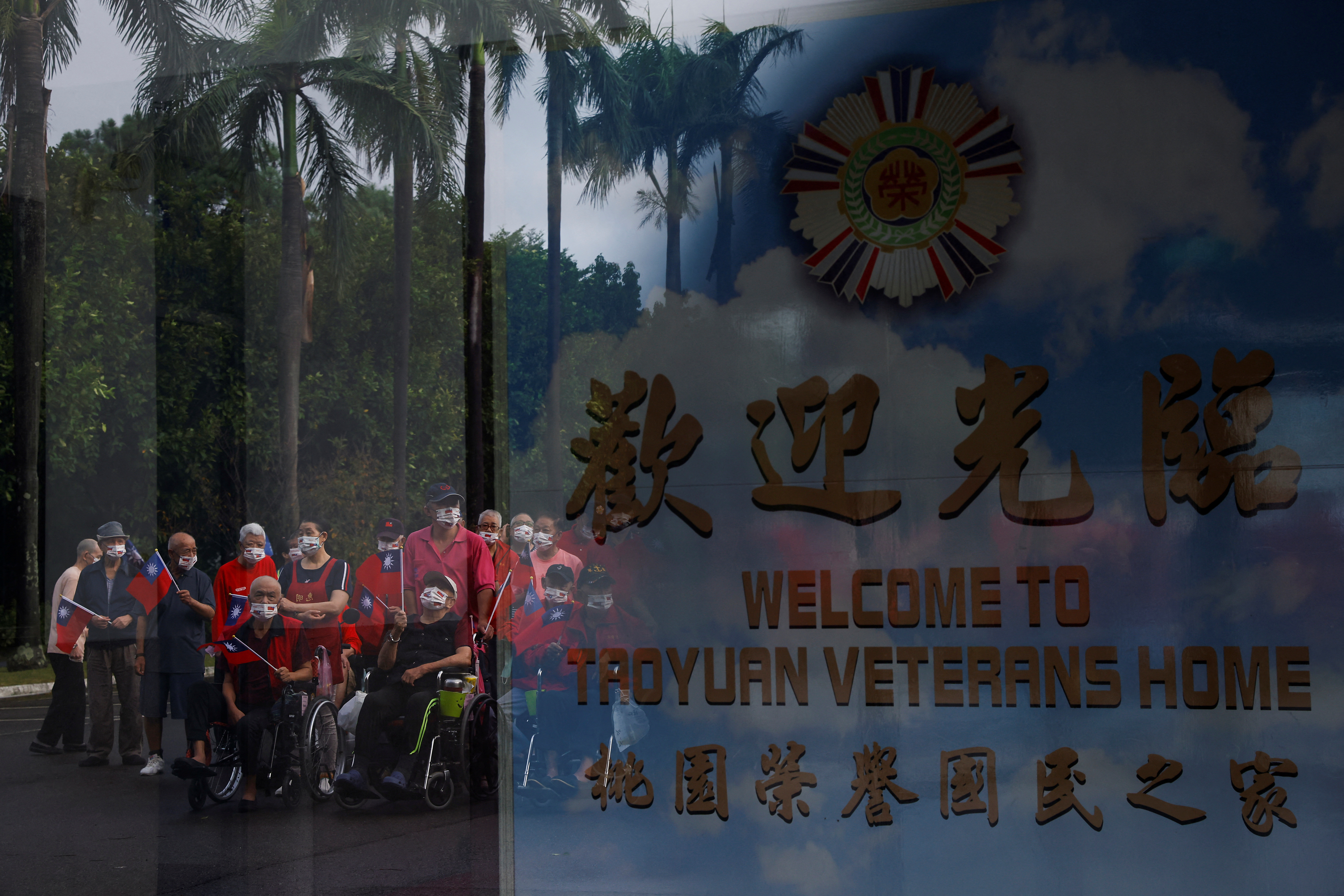 Residents of Taoyuan Veterans Home gather to sing the national anthem and wave Taiwanese flags during the National Day celebrations in Taoyuan, Taiwan.