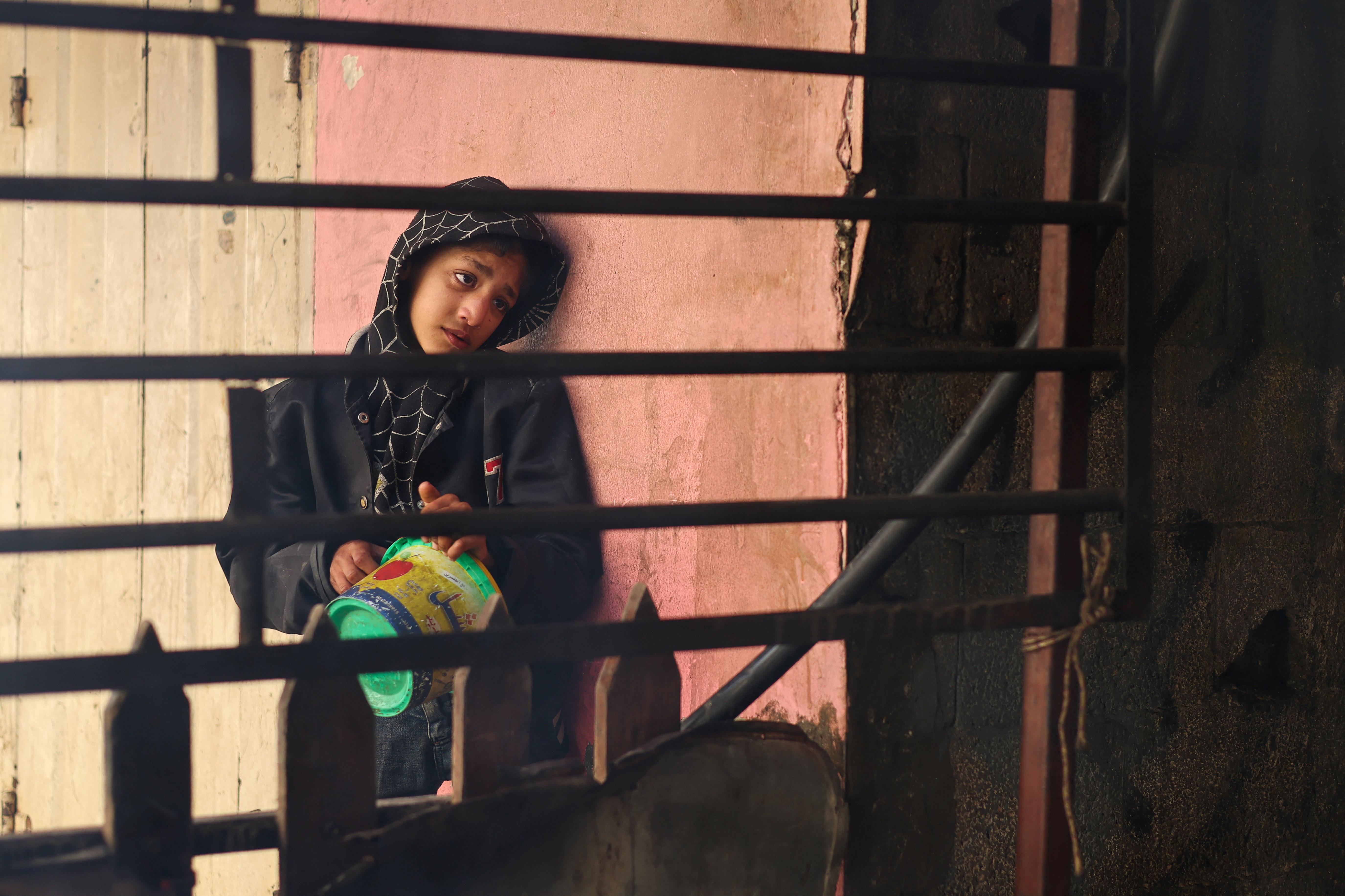 A Palestinian child waits to receive food cooked by a charity kitchen, amid shortages in food supplies, as the conflict between Israel and Hamas continues, in Rafah in the southern Gaza Strip.