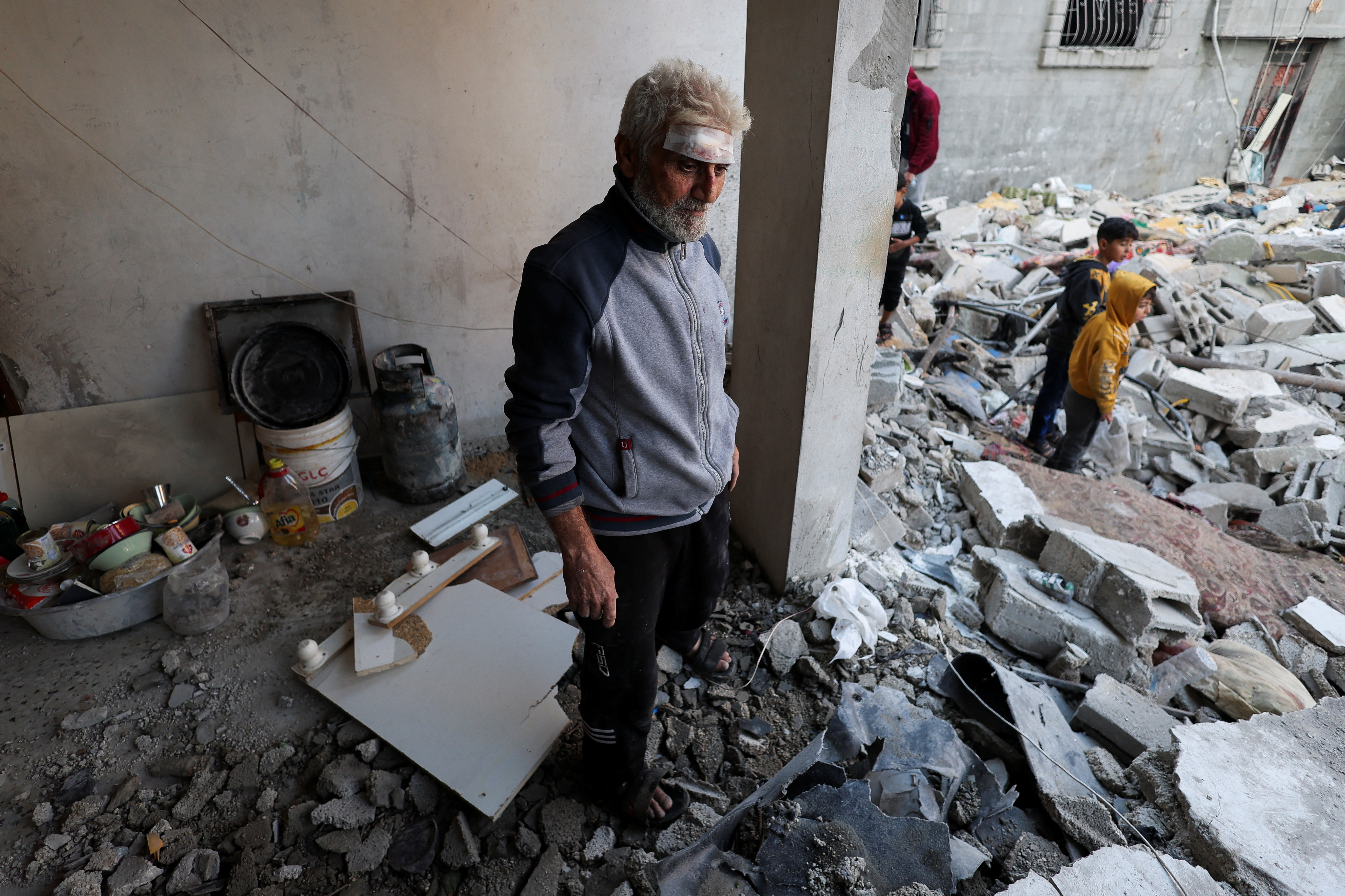 Palestinians inspect the site of an Israeli strike on a house in Rafah.