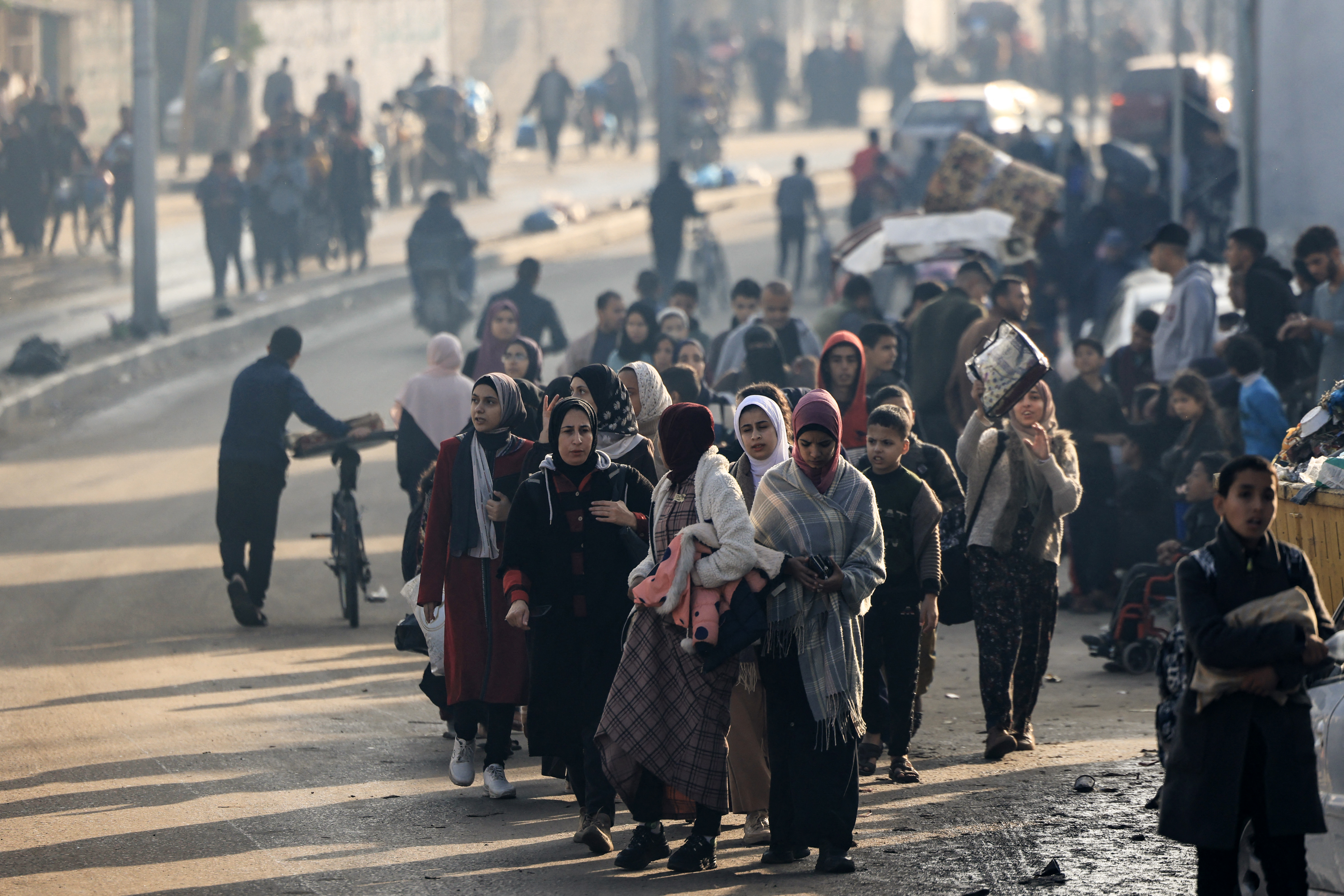 Palestinians walk toward safer areas following the resumption of Israeli strikes on Rafah in the southern Gaza
