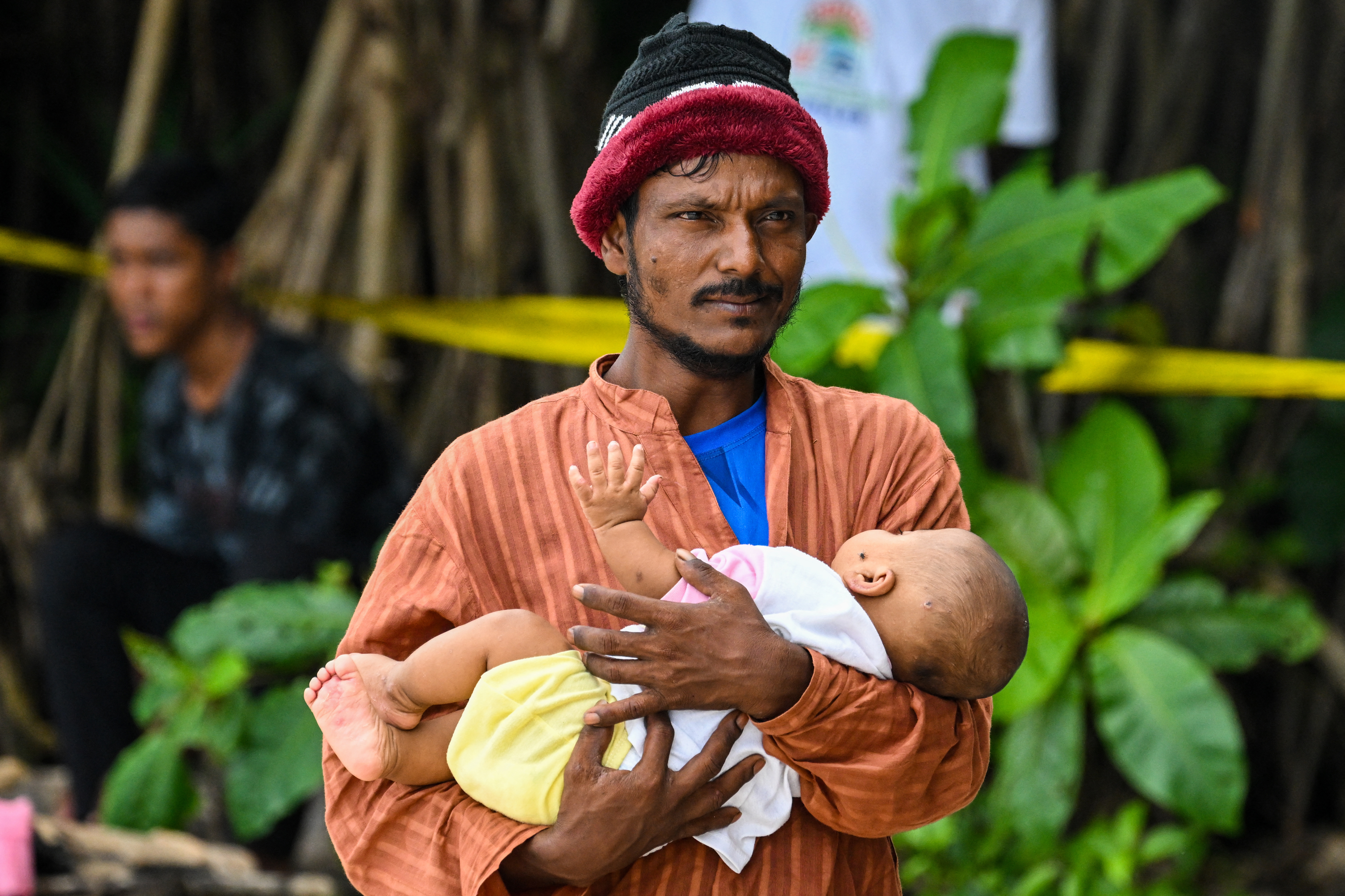 A newly-arrived Rohingya refugee carries a child at a beach on Sabang island, Aceh province, on December 2