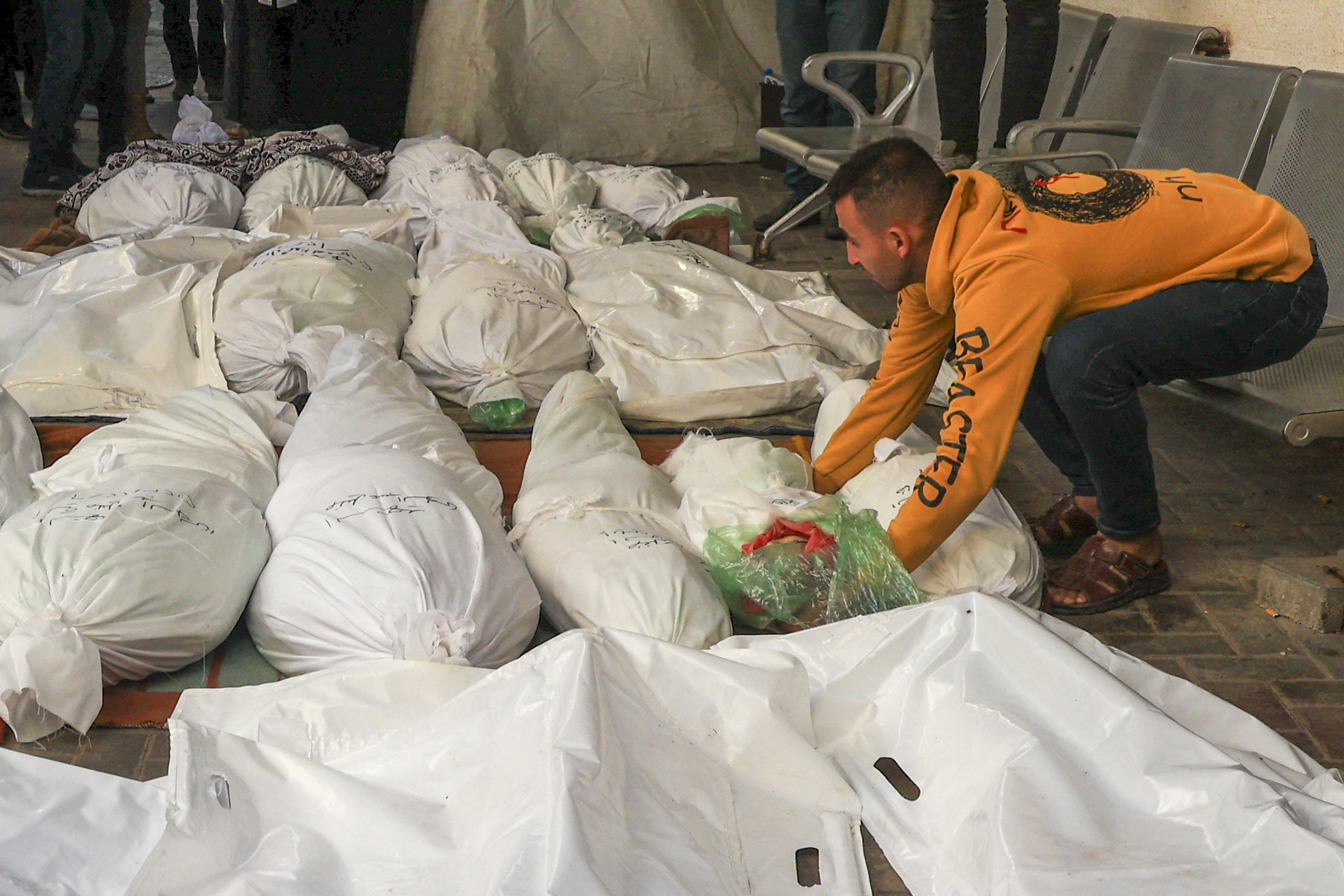 The father of two-year-old Muhammad Saleh Farhat, who was killed with others during Israeli bombardment overnight, places his body among victims outside al-Najjar hospital in Rafah on the southern Gaza Strip.