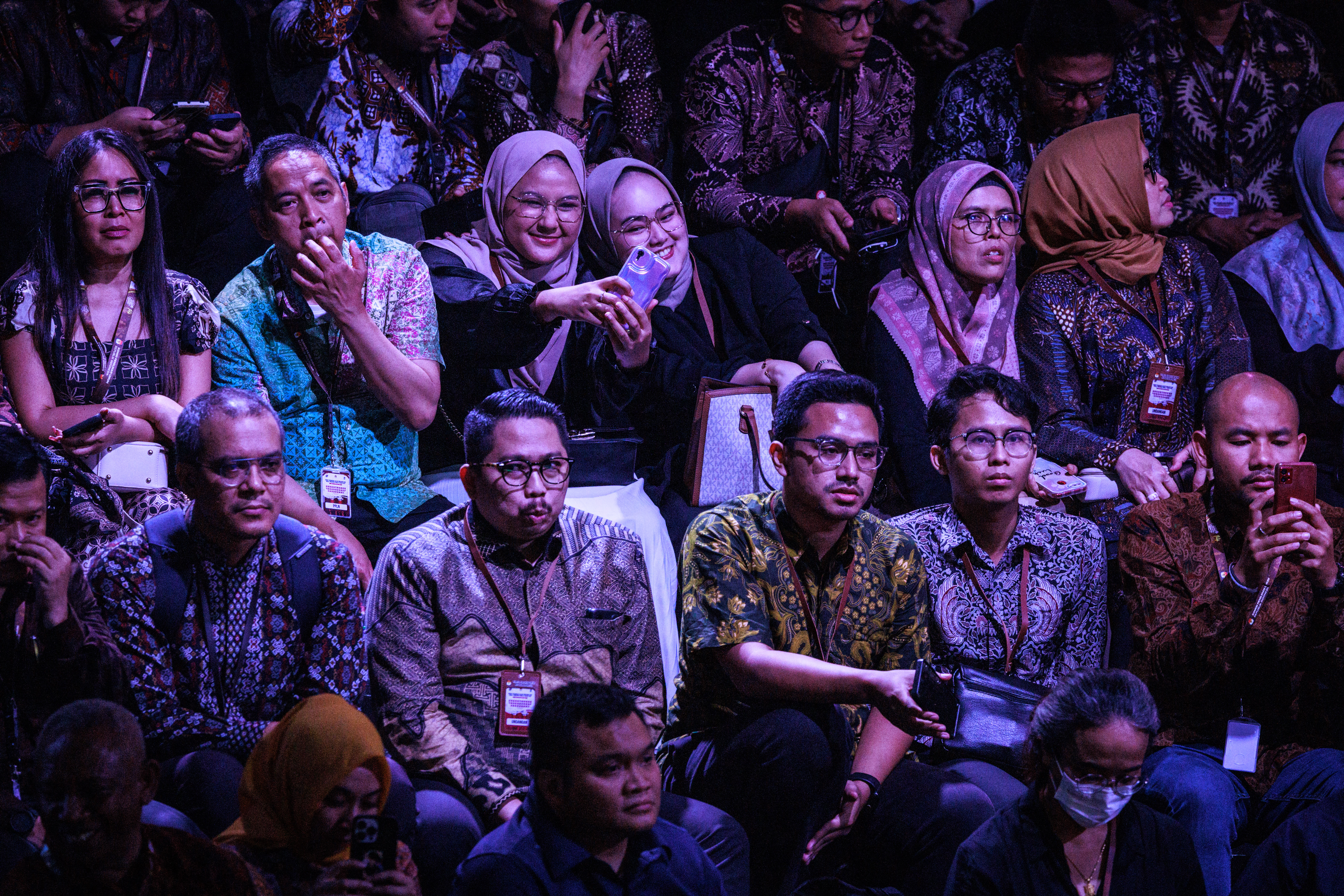 The audience watching the debate. They look animated.