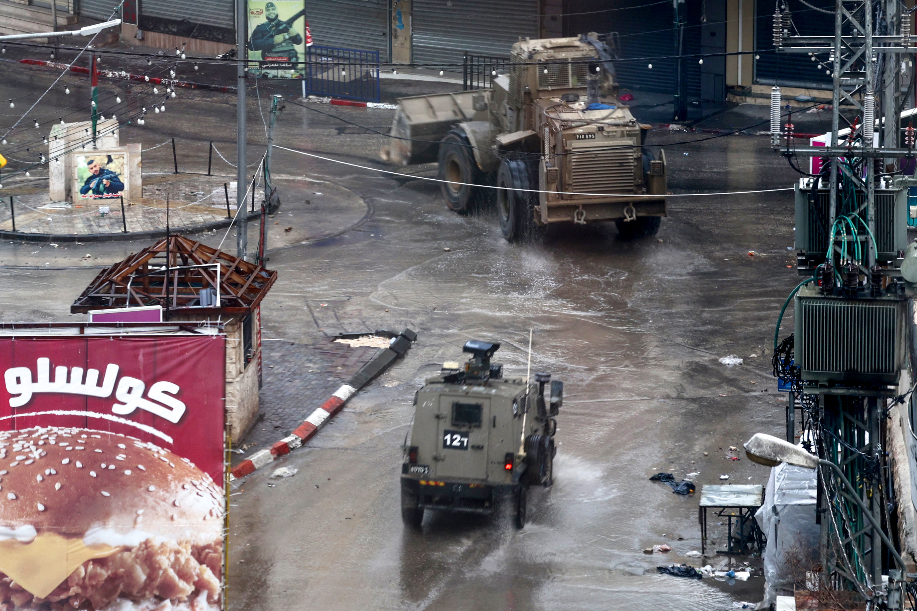 Israeli army vehicles drive through Jenin in the occupied West Bank, on December 13, 2023, following an overnight army raid in the city, as battles continue between Israel and the militant movement Hamas in Gaza.