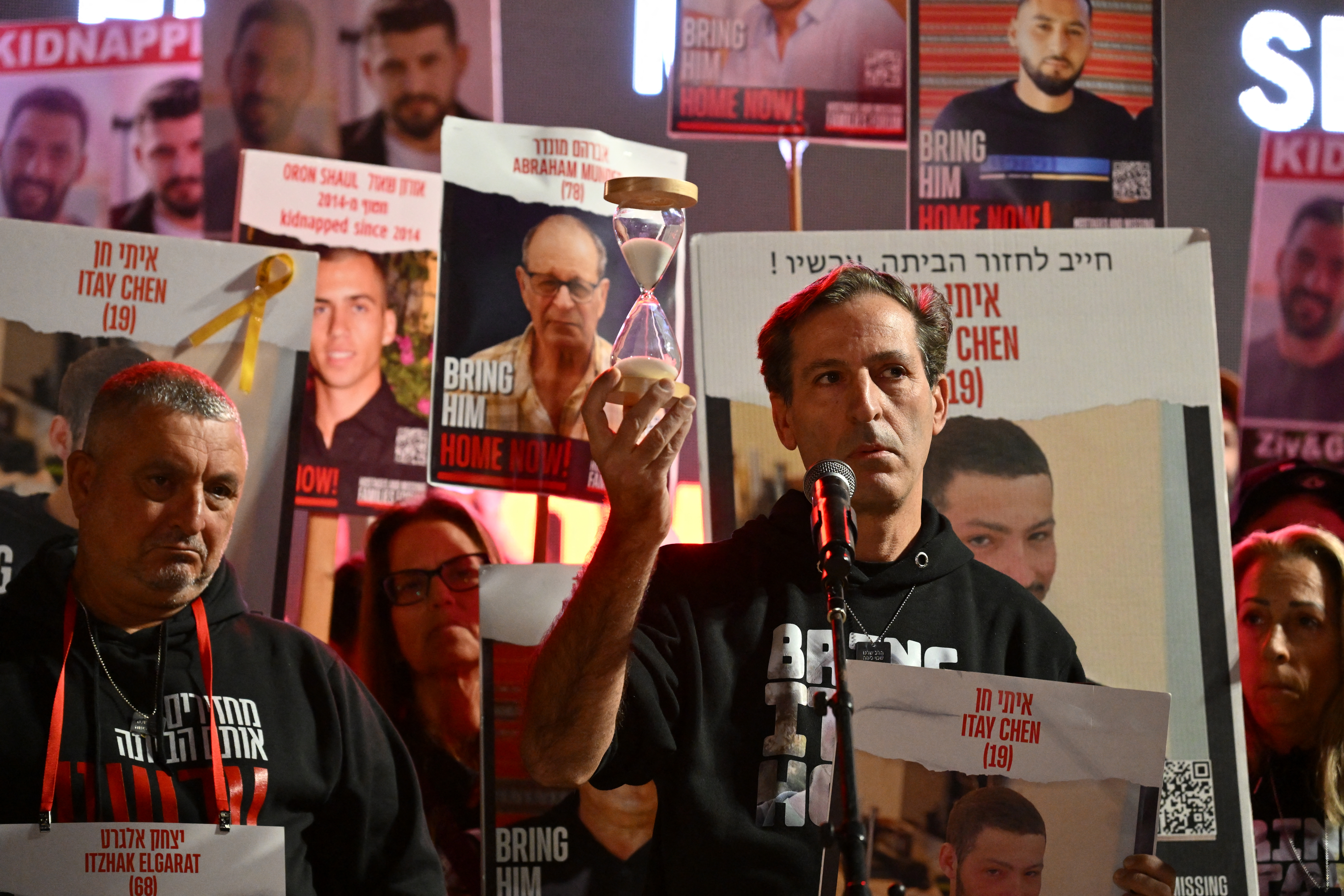 Ruby Chen, father of Israeli hostage Itay, held in Gaza since the October 7 attack, lifts an hourglass as he delivers a statement to the media in Tel Aviv on December 16, 2023. (Photo by Alberto PIZZOLI / AFP)