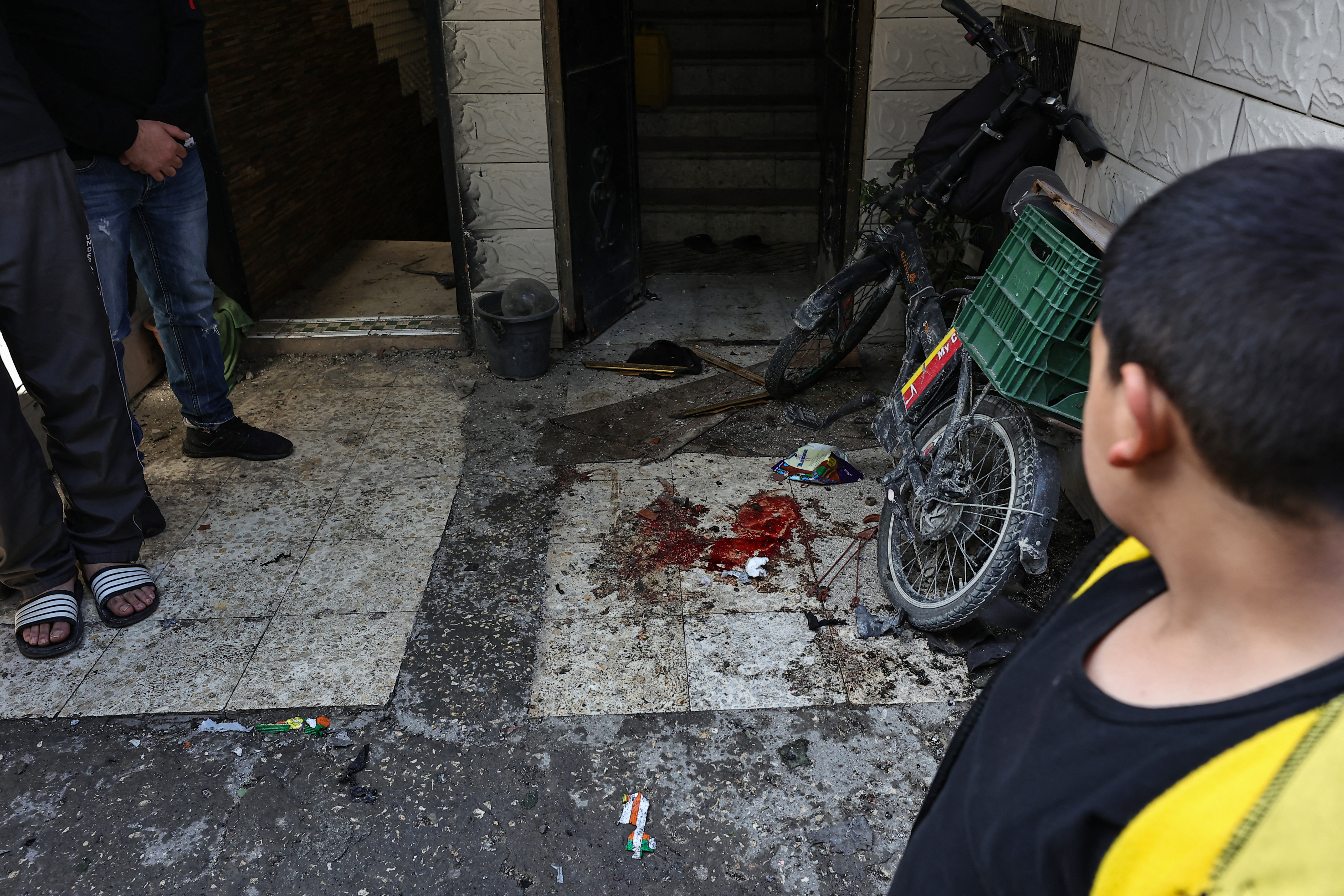 A boy looks at a blood stain at the reported site where Palestinians were killed in an Israeli raid in the Nur Shams camp for Palestinian refugees near the northern city of Tulkarm in the occupied West Bank on December 17