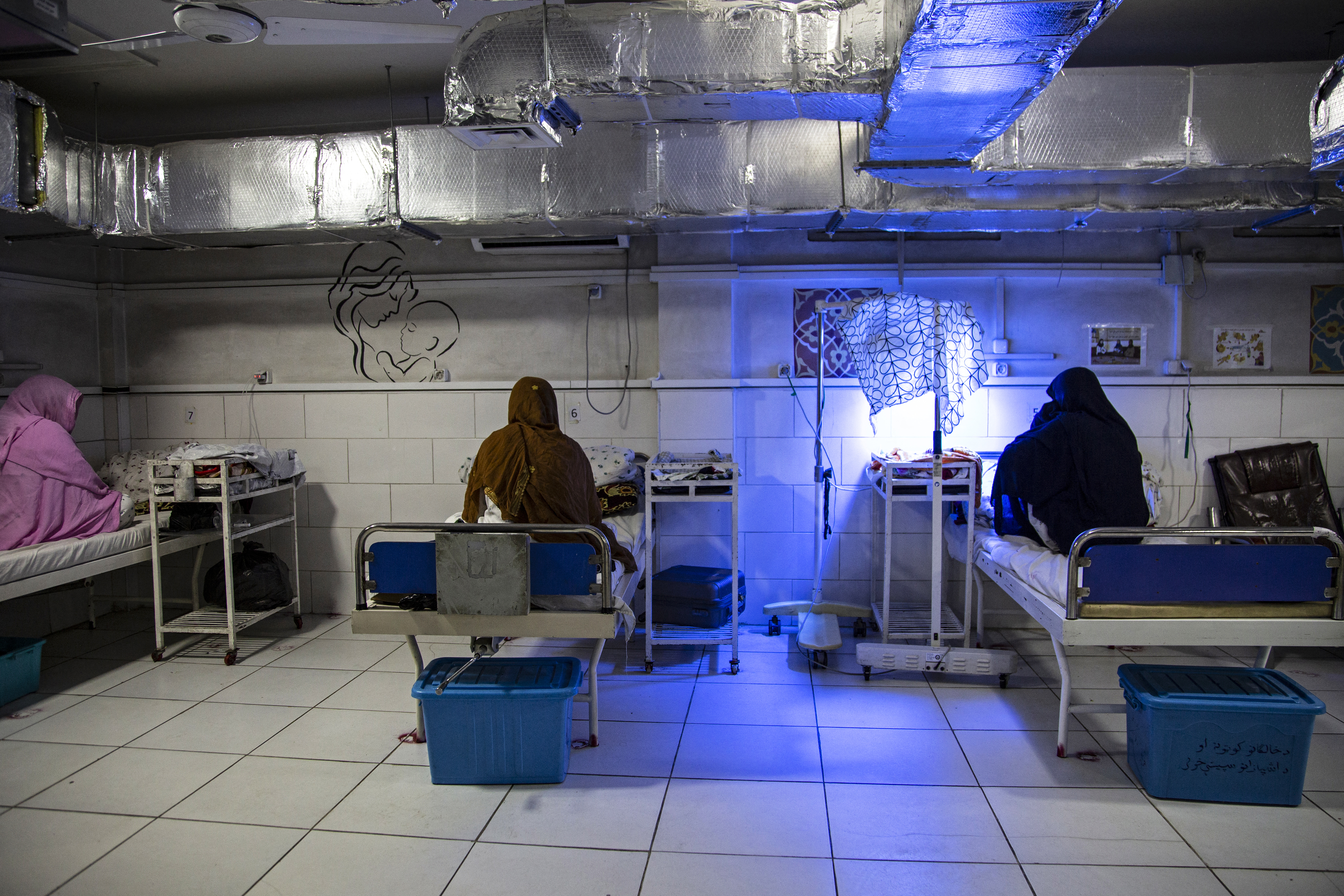 In this photograph taken on December 8, 2023, Afghan women sit beside their newborns at the Doctors Without Borders (MSF)-run maternity hospital in Khost.