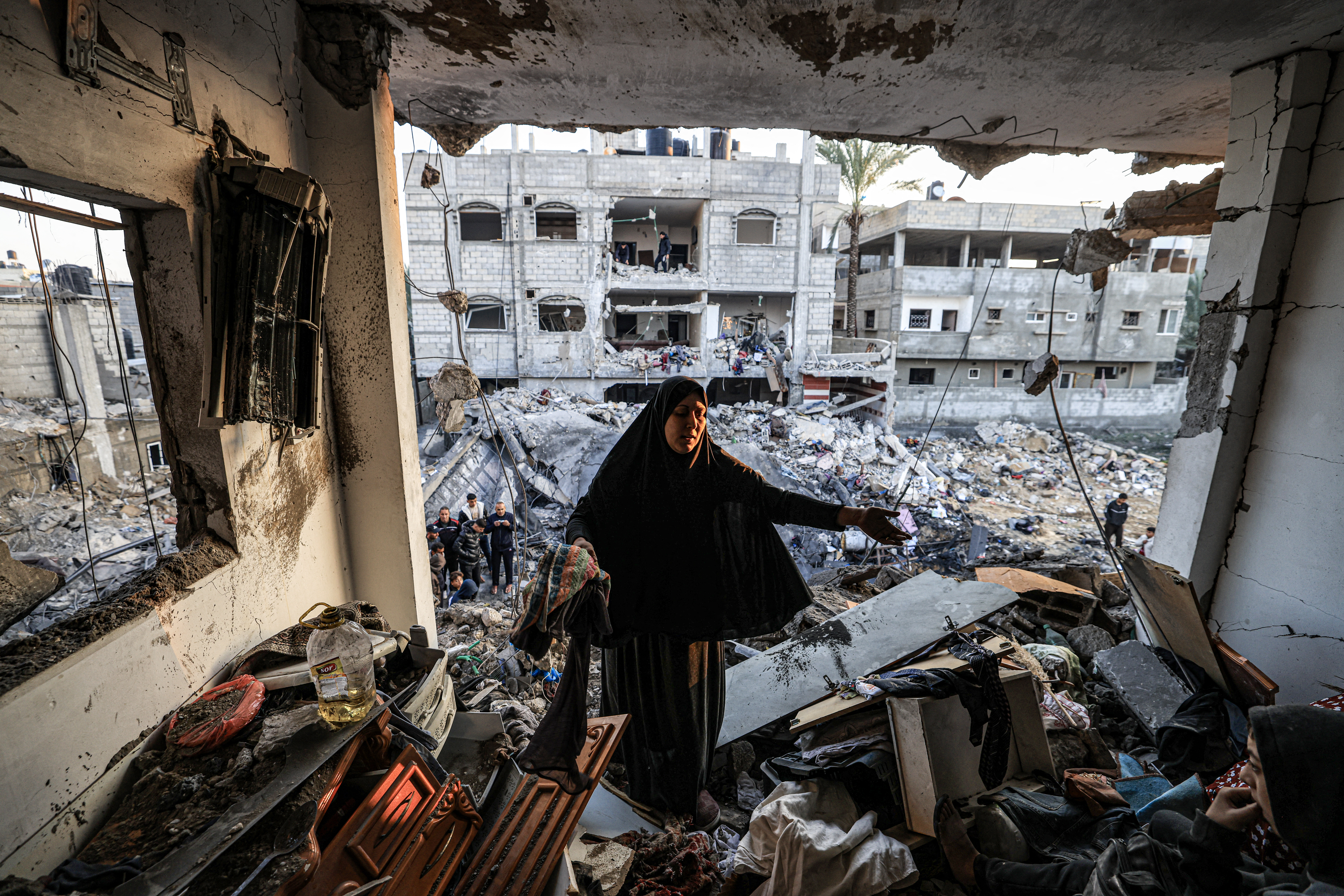 A woman inspects the destroyed building of Palestinian journalist Adel Zorob, who was killed overnight in an Israeli bombardment, in Rafah in the southern Gaza Strip.