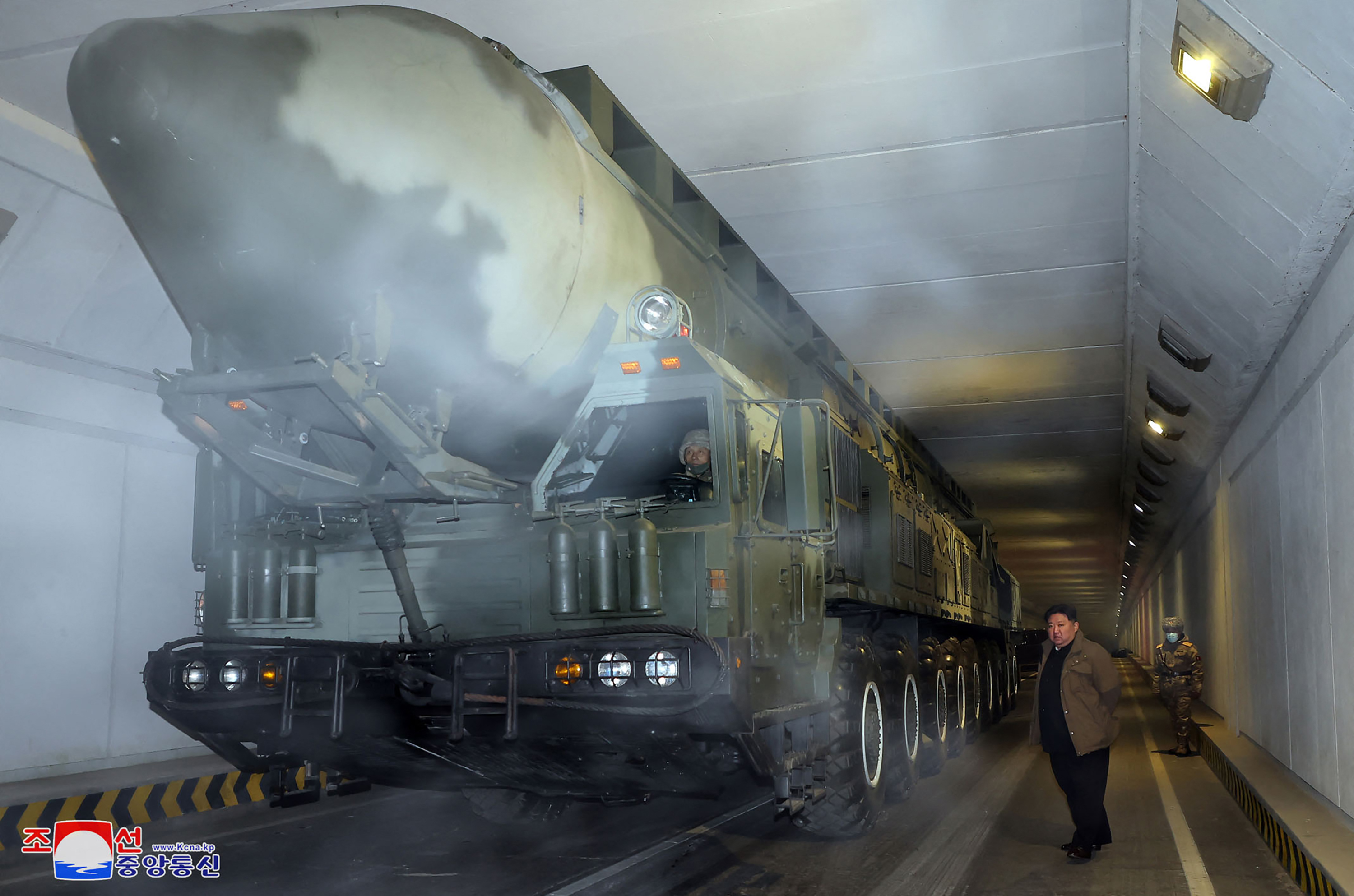 Kim Jong Un inspecting the launch preparation status of a Hwasong-18 ICBM. He is standing next to the weapon on its launcher in a tunnel