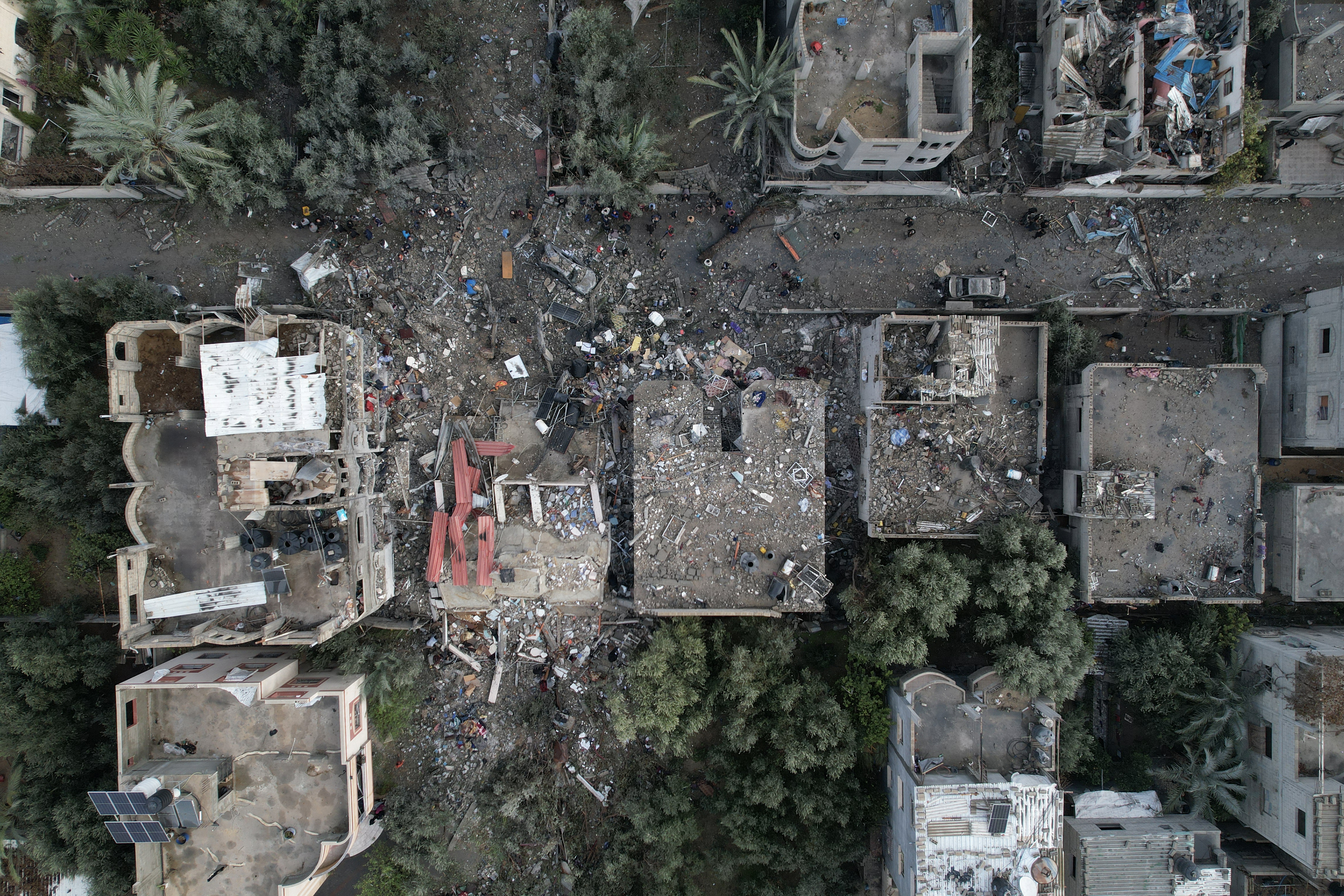 An aerial view shows Palestinians inspecting the damage at the Al-Maghazi refugee camp after an overnight Israeli strike on December 25