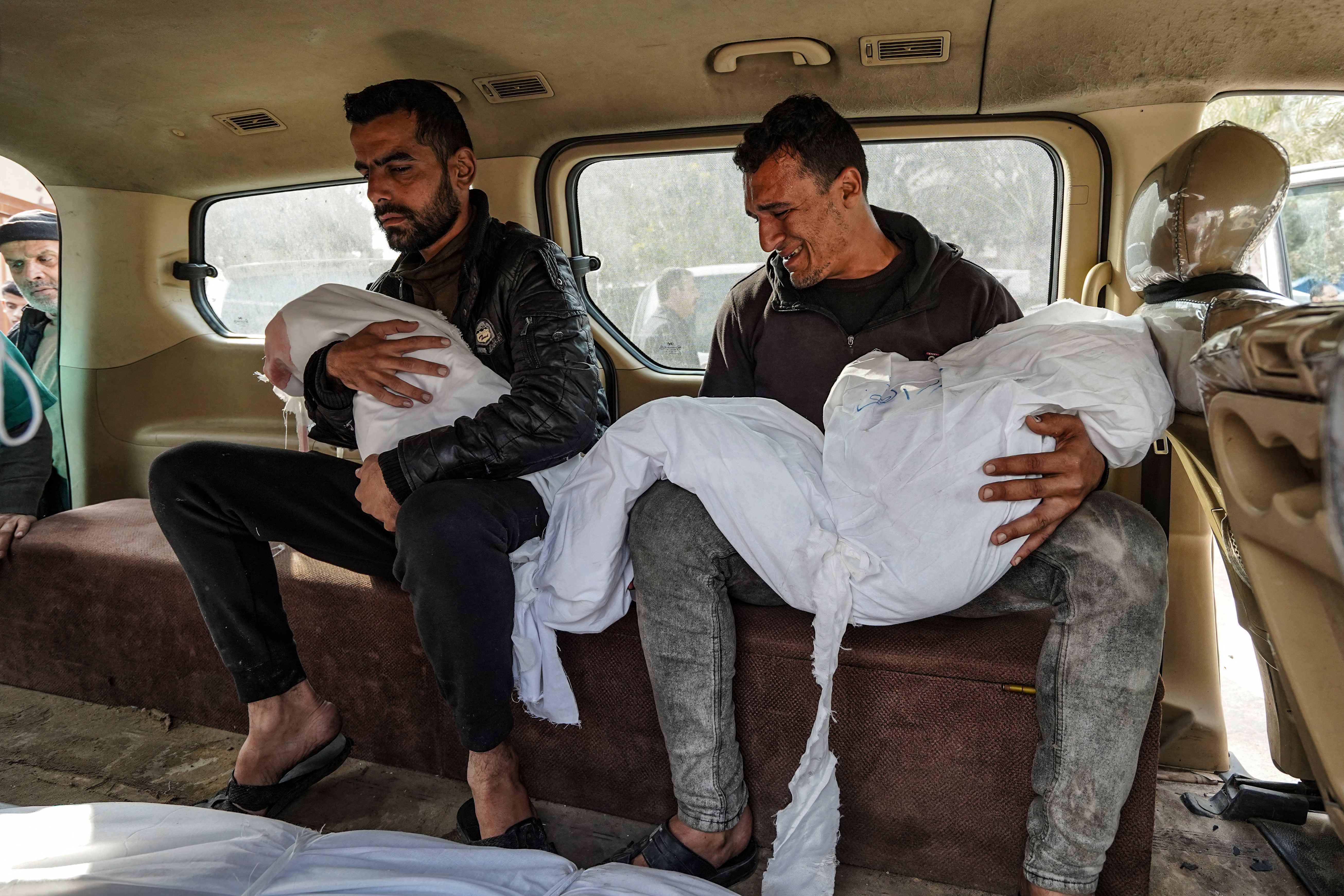 Palestinians carry the shrouded bodies of relatives, killed in Israeli strike, at the Nasser hospital in Khan Yunis