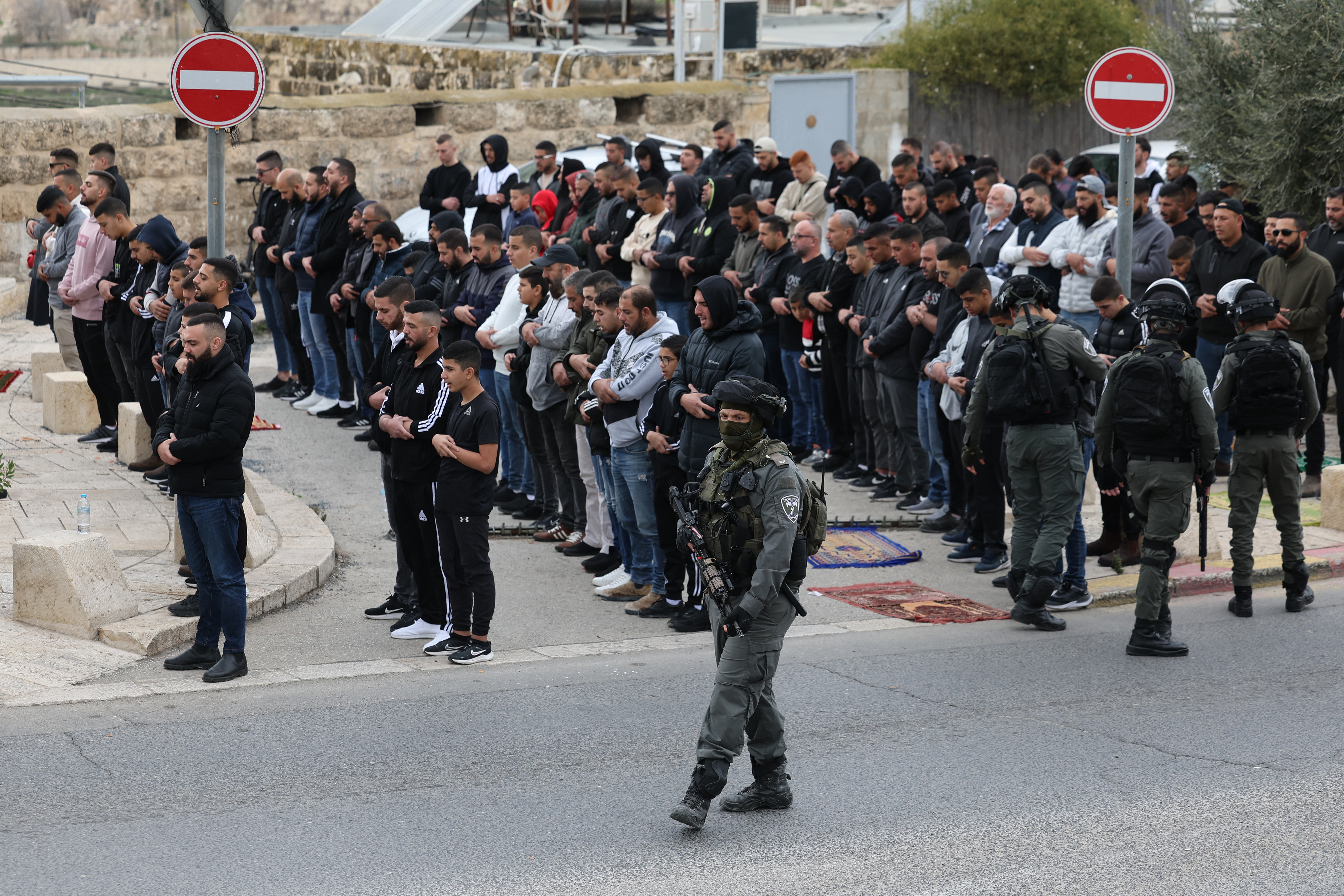 Israeli security forces stand guard as Palestinian Muslims gather for Friday prayer in east Jerusalem on December 29