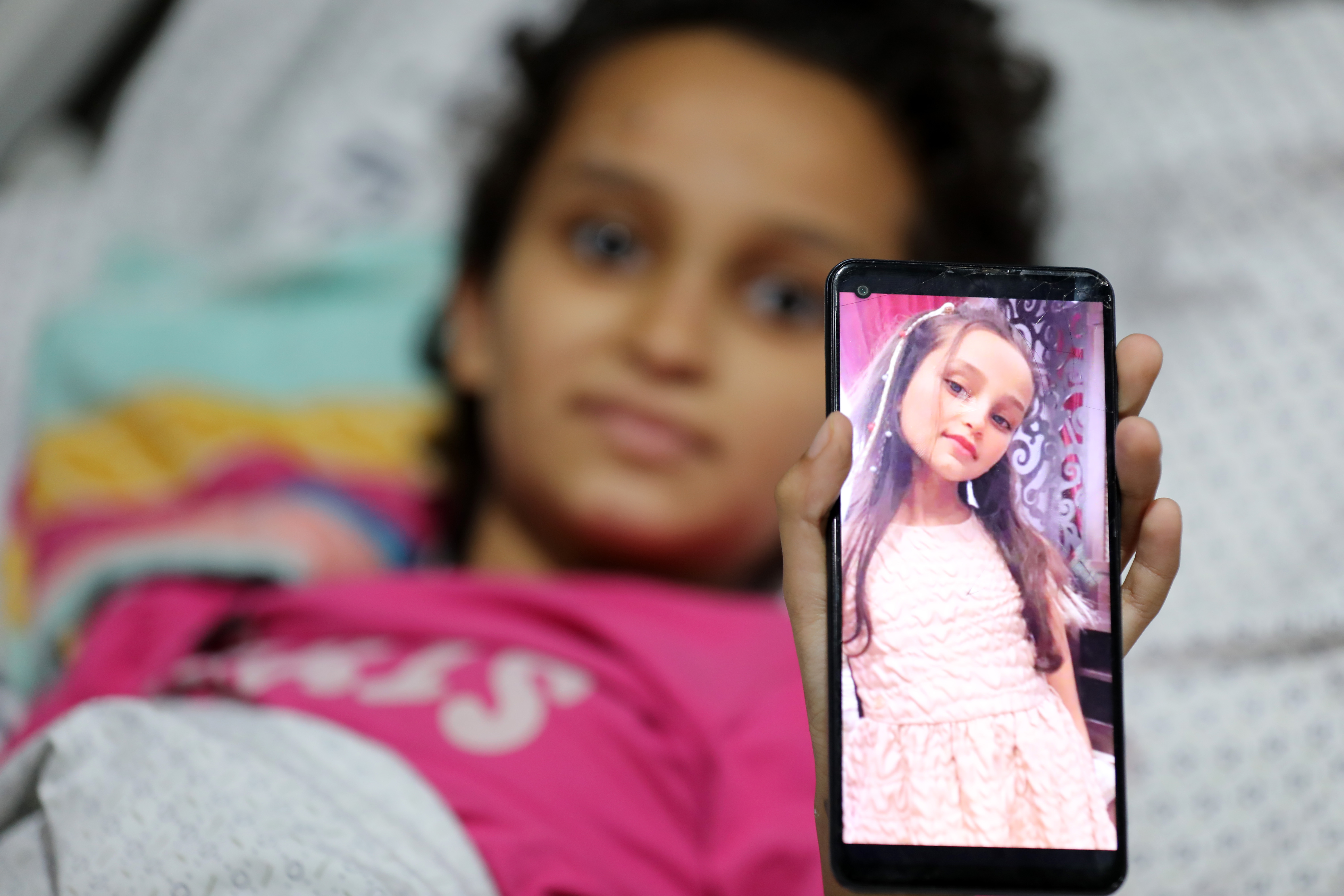 Mayar Abu Saad shows off a photo of herself before the war with long hair 