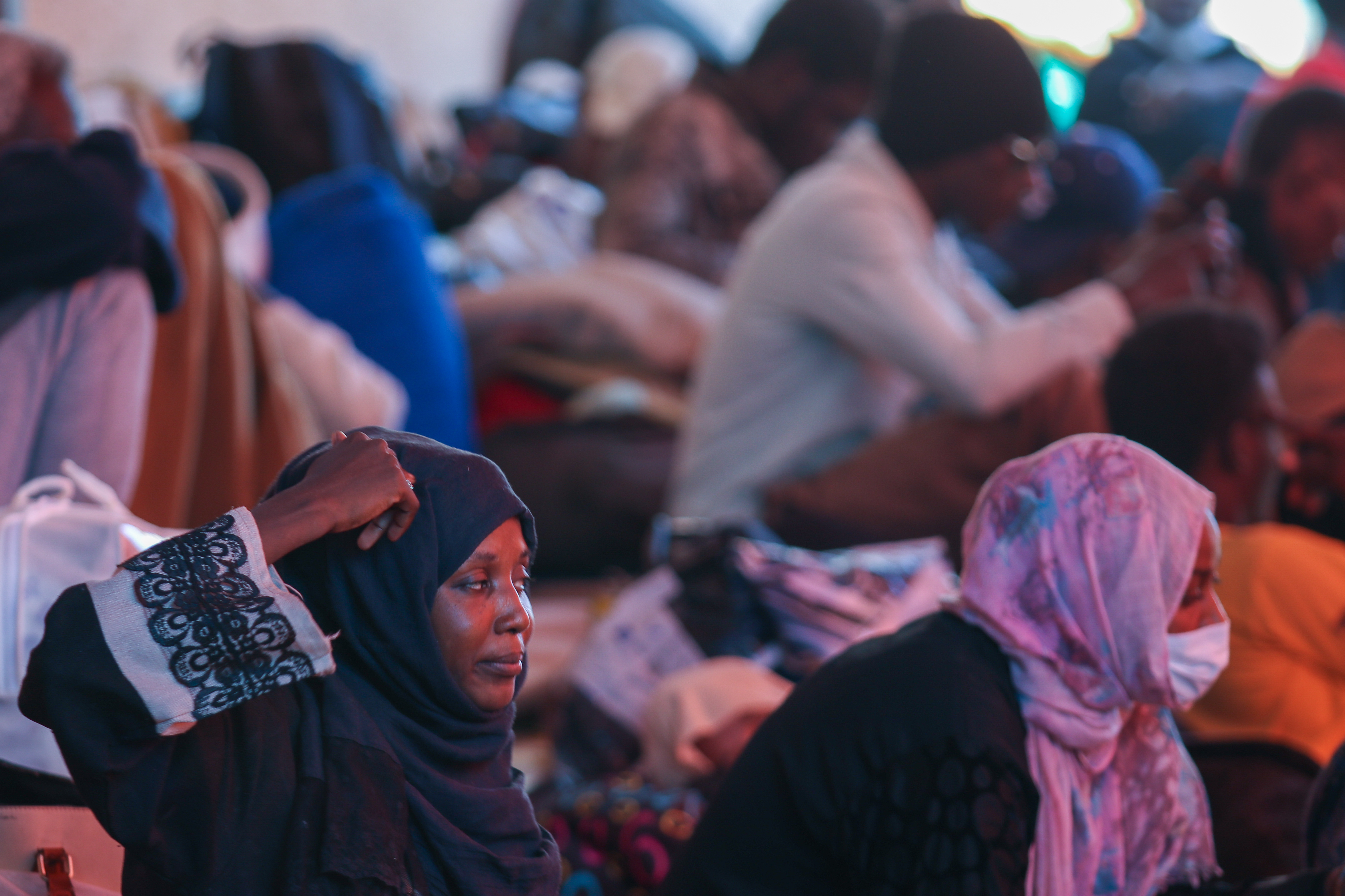 Refugees sitting in tents in front of the UNHCr