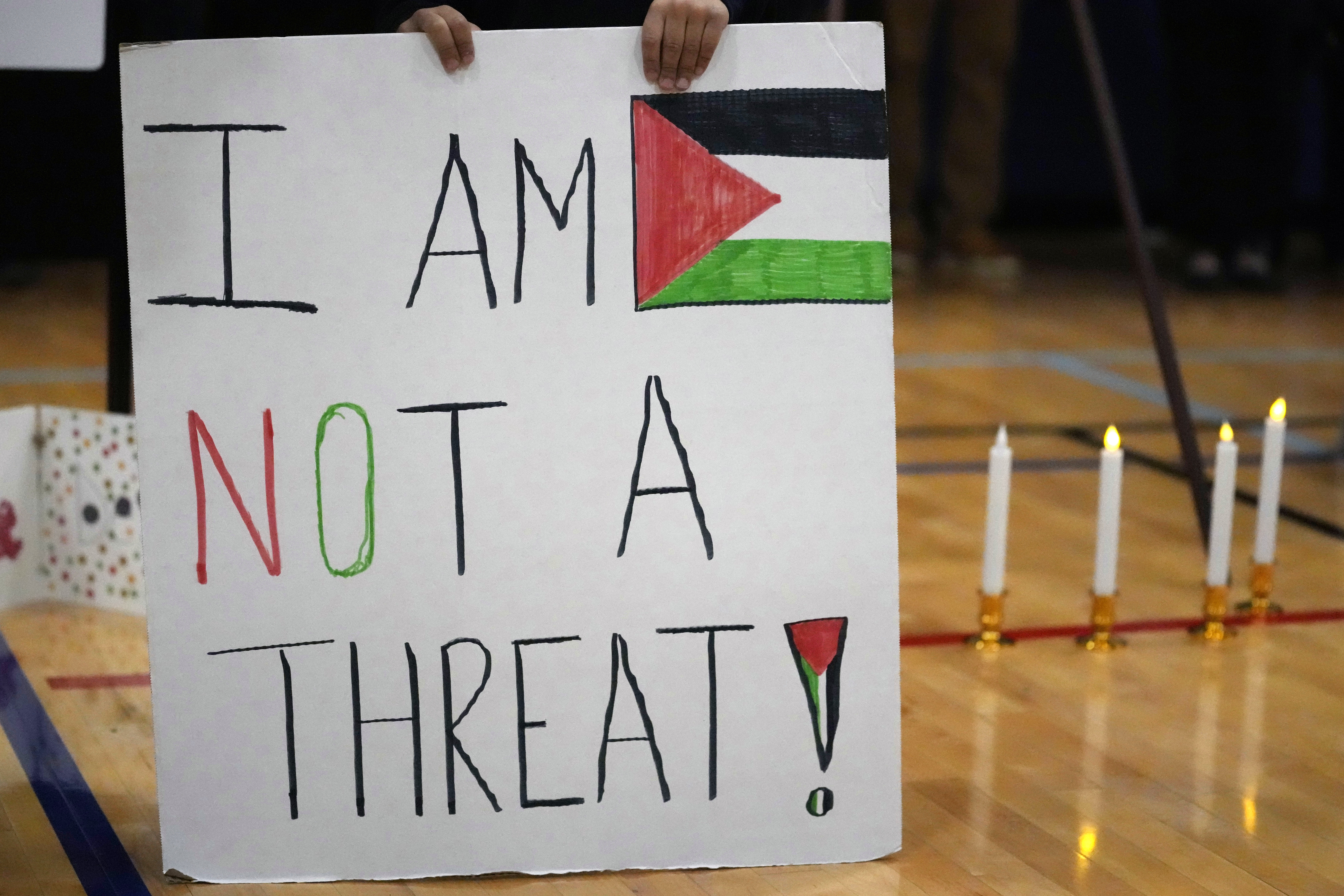 Easton Amjad Waz, 5, holds a sign during a vigil for Wadea Al Fayoume at Prairie Activity and Recreation center in Plainfield, Ill., Tuesday, Oct. 17, 2023. An Illinois landlord accused of fatally stabbing the 6-year-old Muslim boy and seriously wounding his mother was charged with a hate crime after police and relatives said he singled out the victims because of their faith and as a response to the war between Israel and Hamas. (AP Photo/Nam Y. Huh)