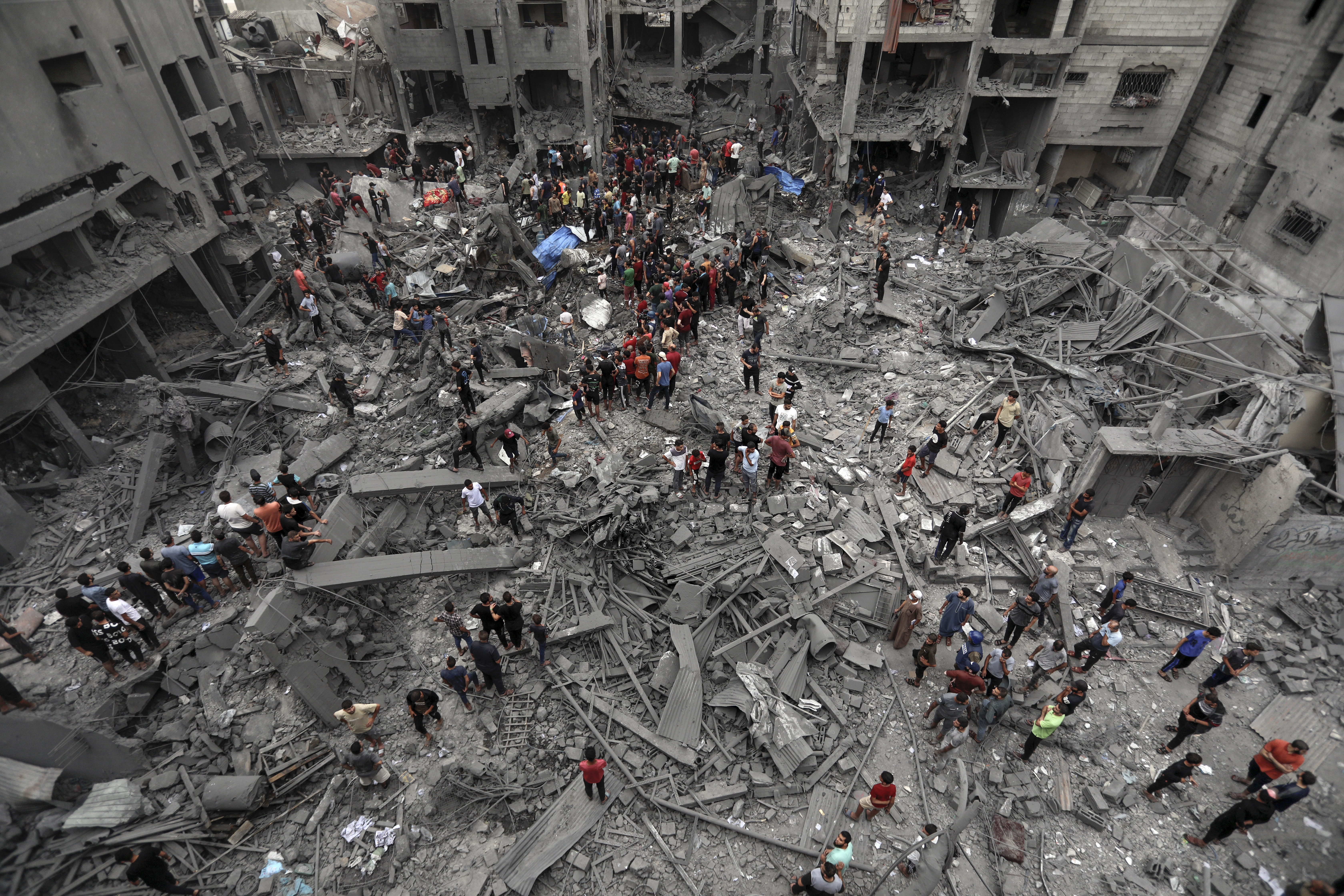 Palestinians inspect the damage of destroyed buildings following Israeli airstrikes on Gaza City