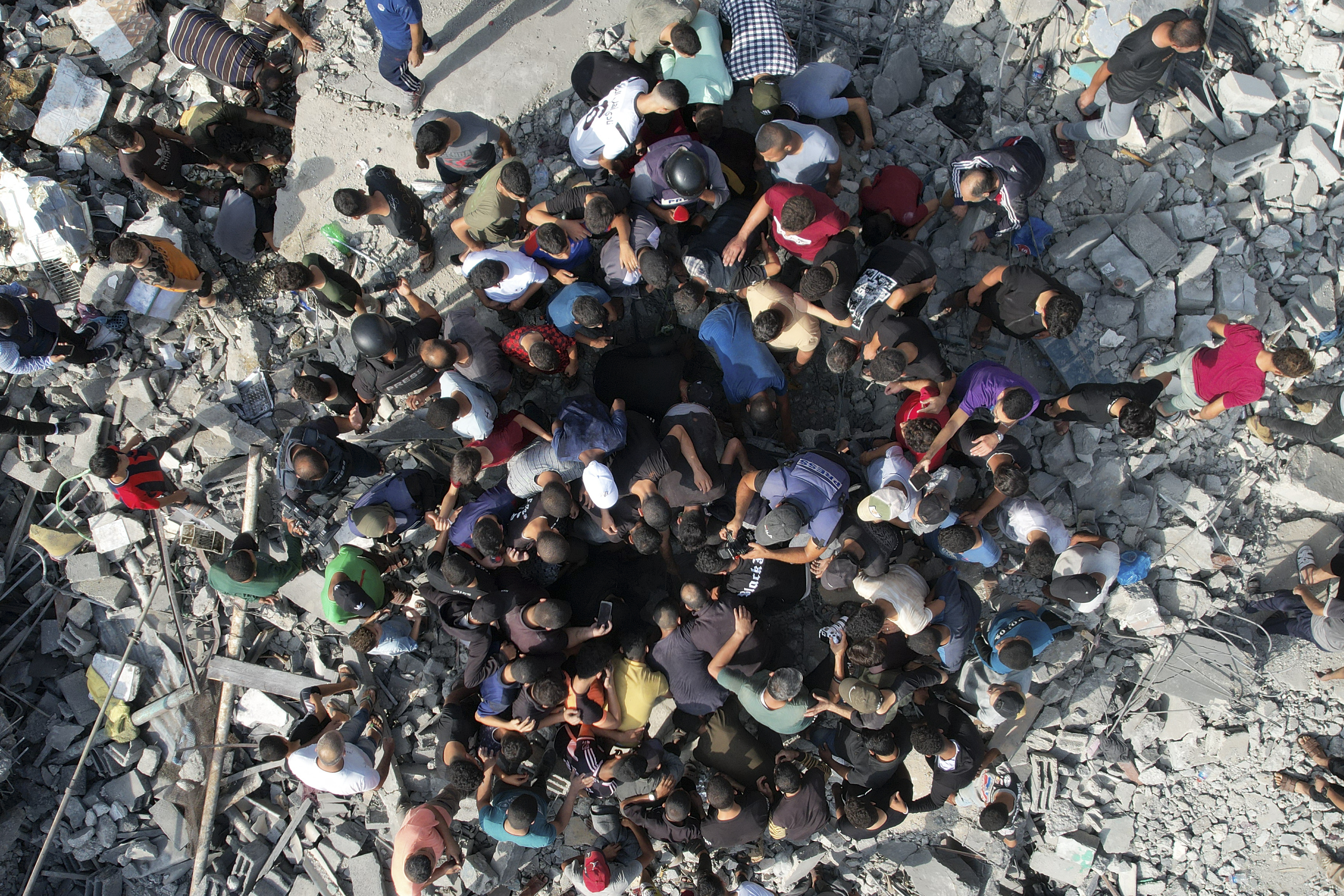 Palestinians look for survivors of the Israeli bombardment in the Maghazi refugee camp in the Gaza Strip