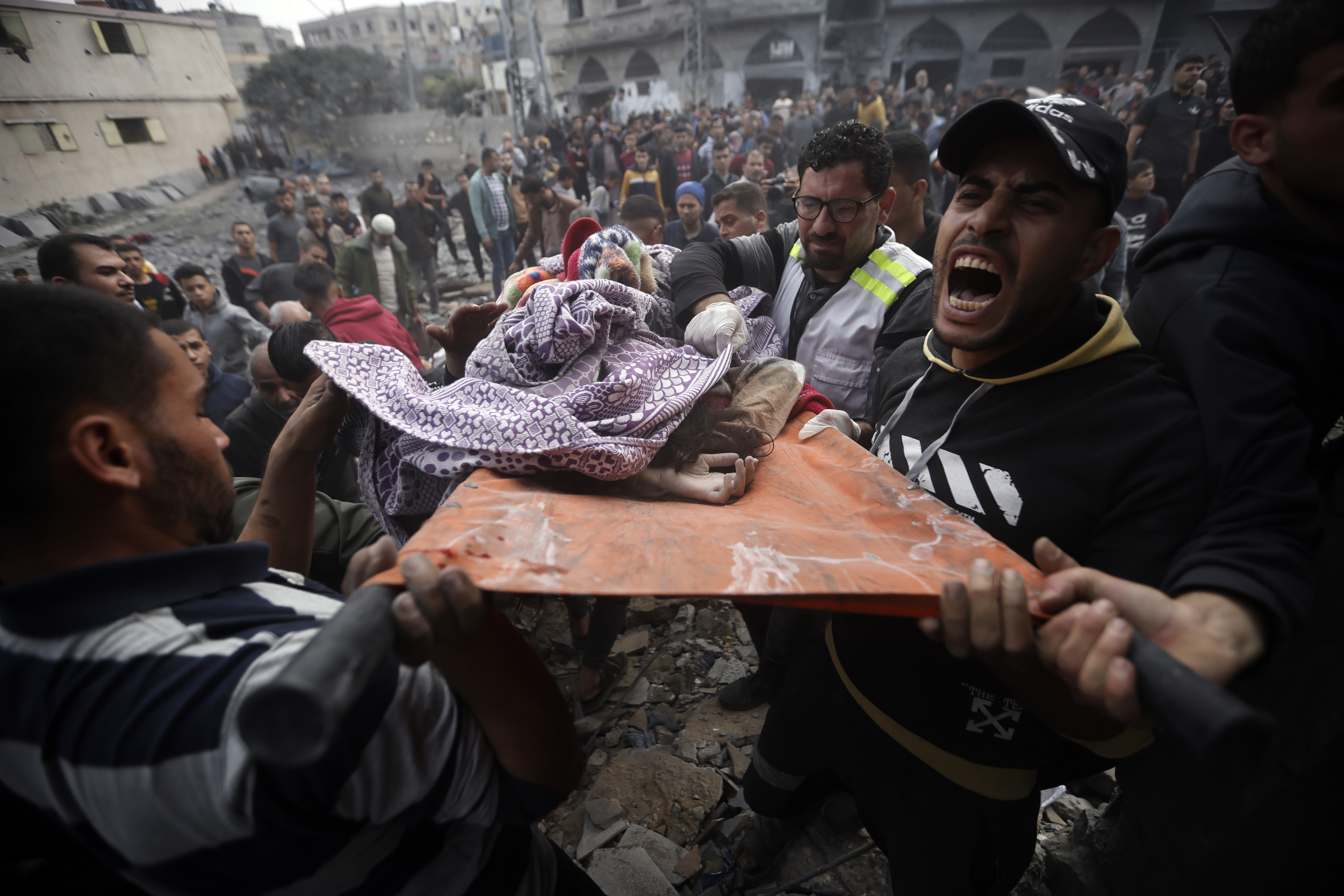 Palestinians carry a dead girl, found under the rubble of a destroyed building following Israeli airstrikes in Khan Younis refugee camp, southern Gaza Strip.