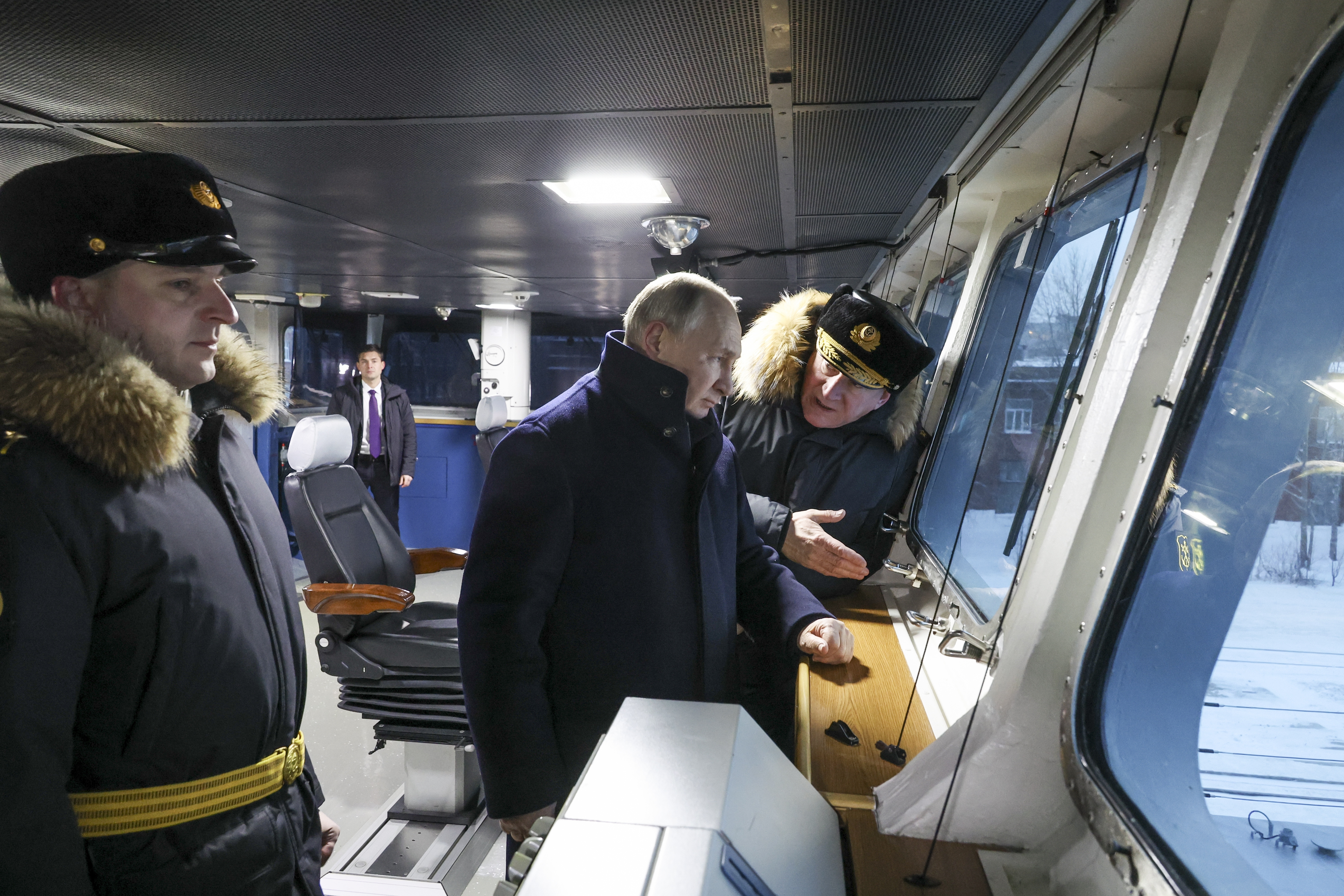 Russian President Vladimir Putin, center, and Admiral Nikolai Yevmenov, Commander-in-Chief of the Russian Navy, right, visit the newest frigate "Admiral of the fleet Kasatonov". They are on the ship's bridge.