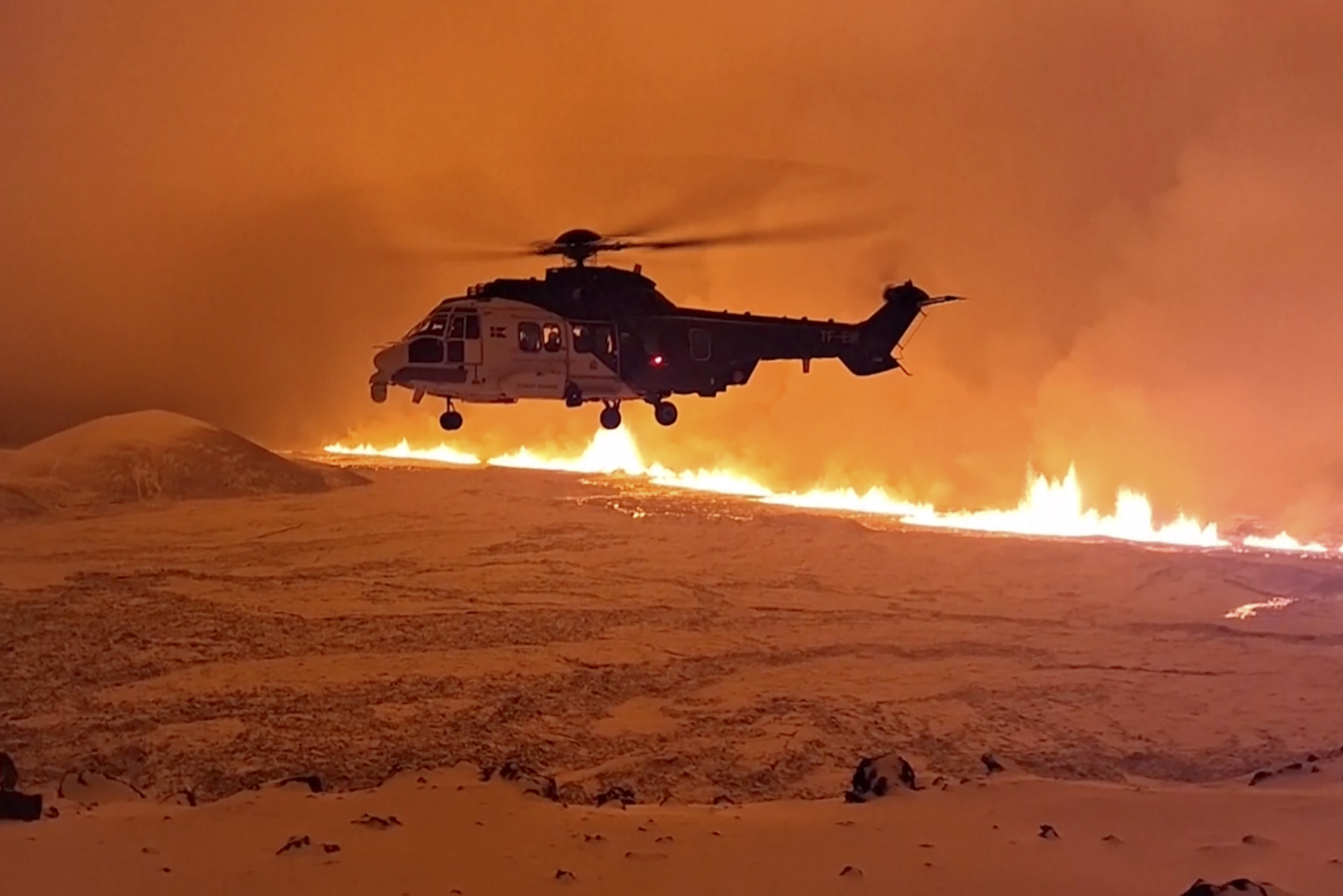 helicopter flying near magma running on a hill