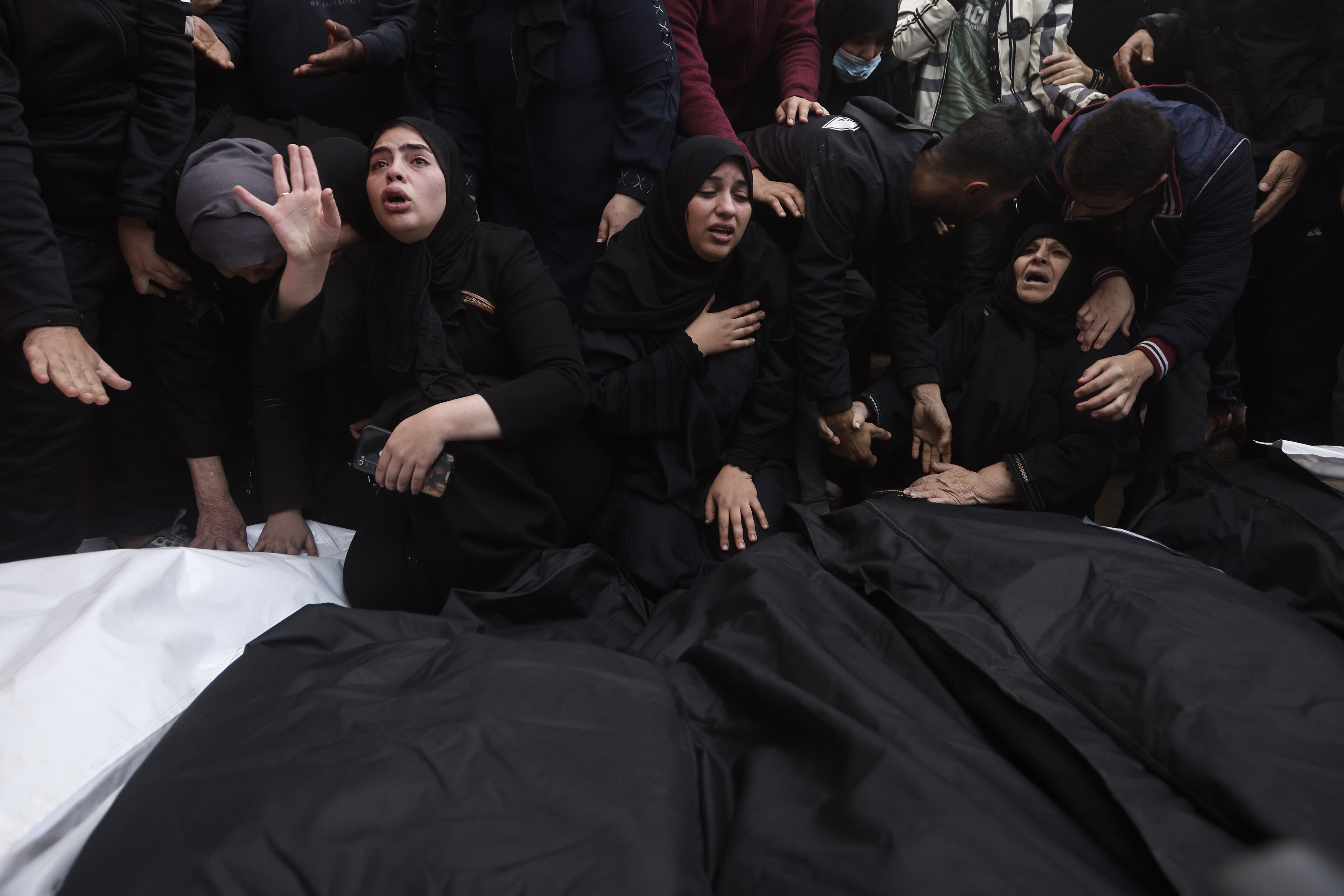 Palestinians mourn relatives killed in the Israeli bombardment of the Gaza Strip outside a morgue in Khan Younis