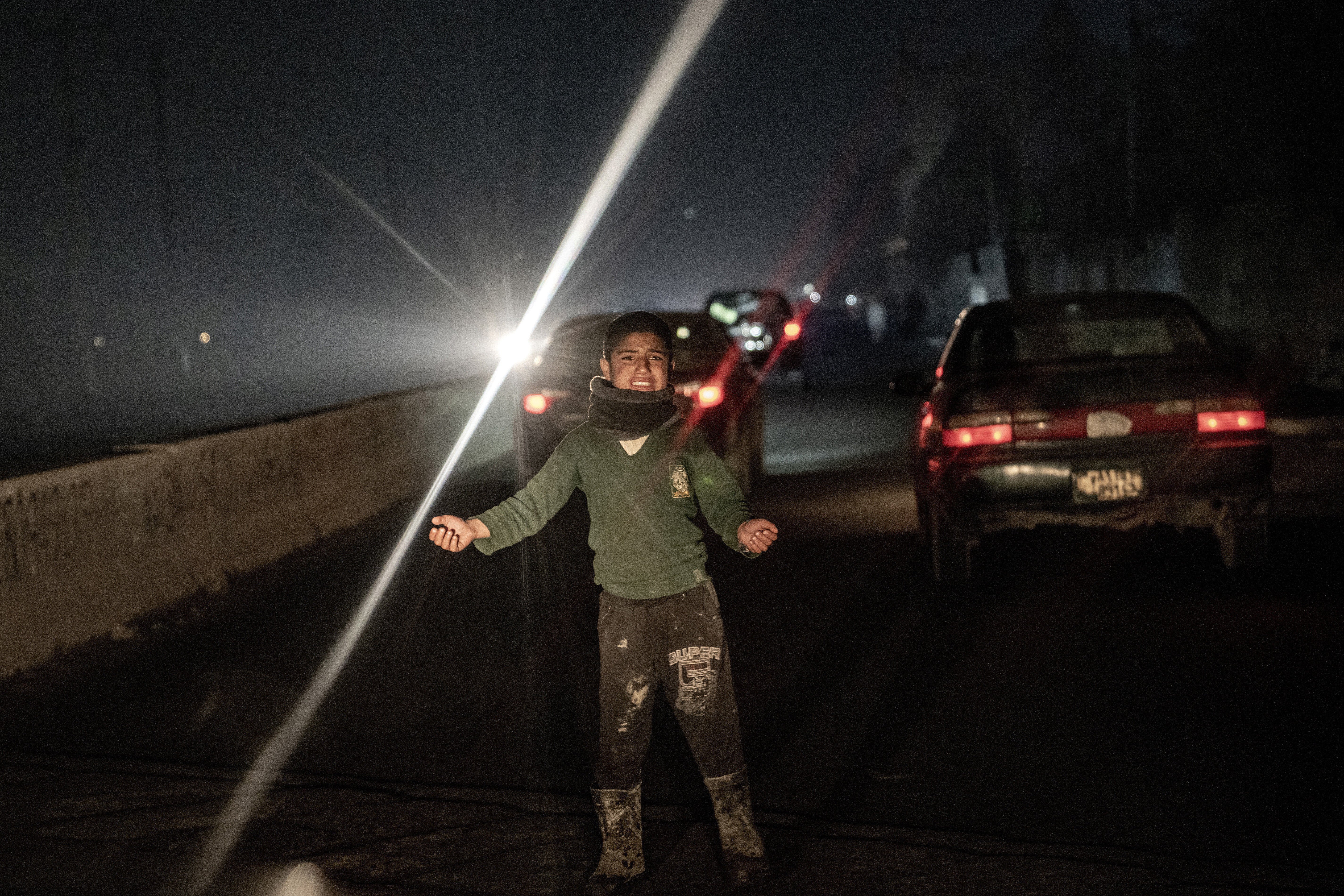 A boy begs in a road near the camp for internally displaced people where he lives in Kabul, Afghanistan, Thursday, Feb. 2