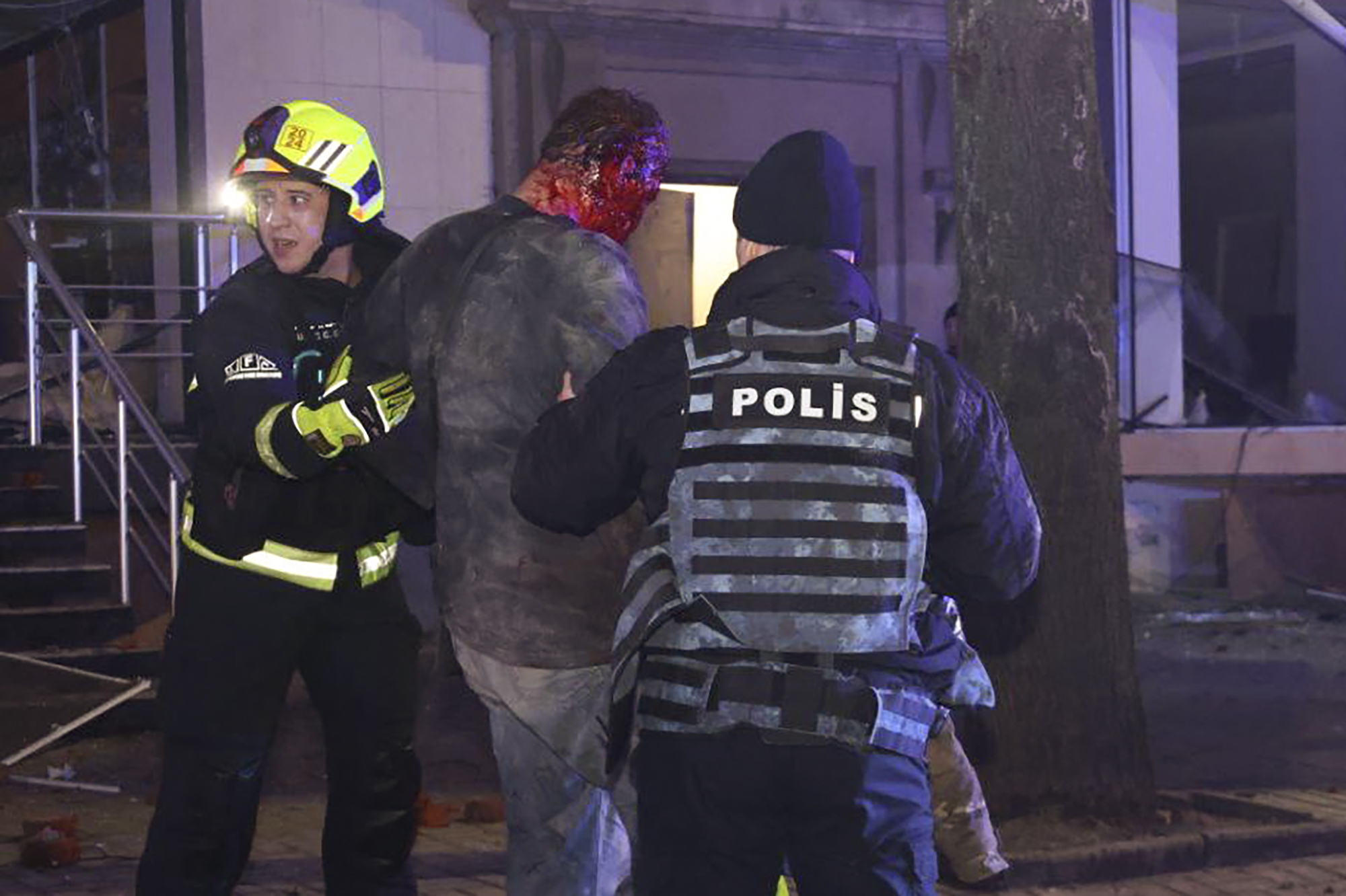 Police and emergency workers help a wounded resident in Kharkiv