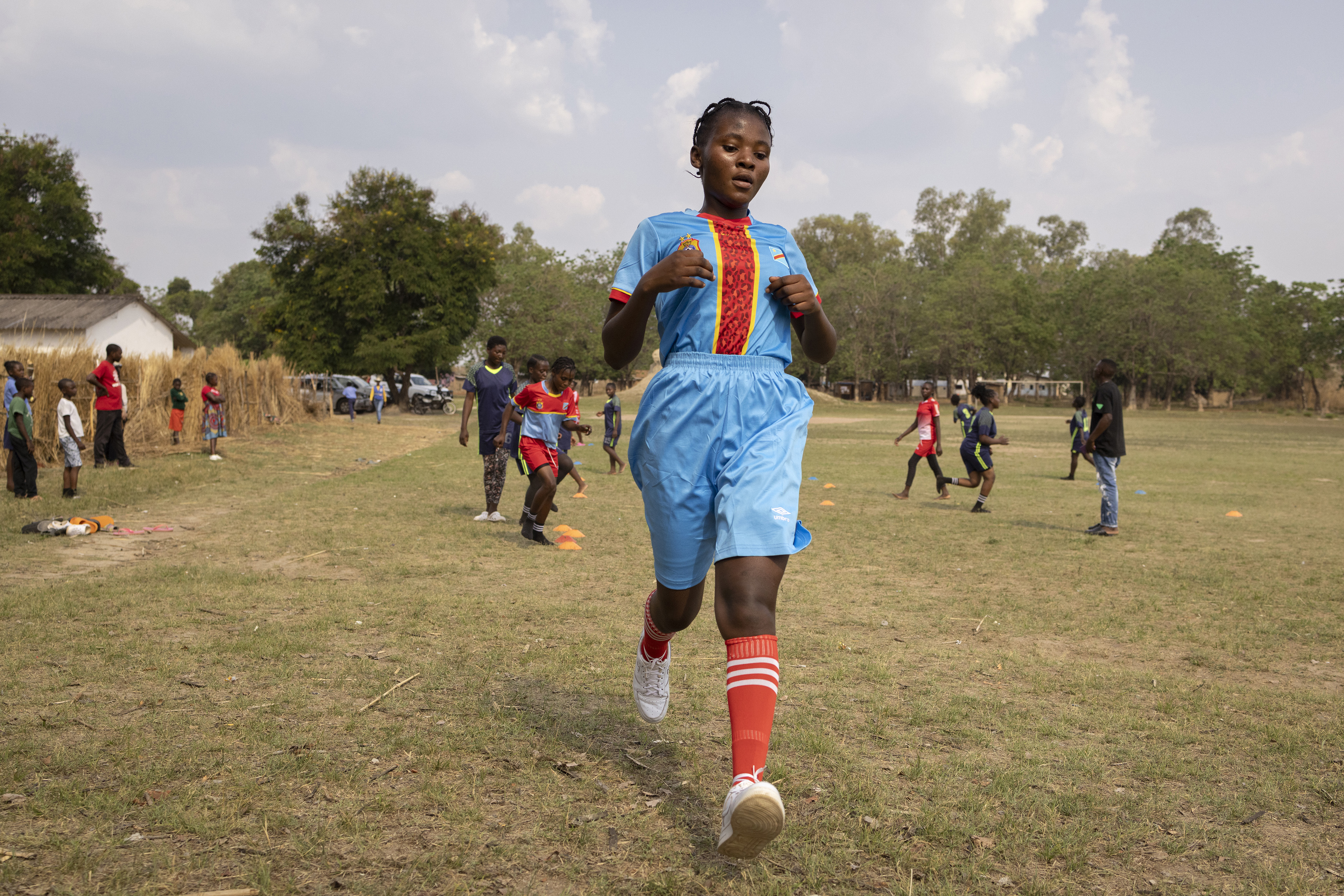 Football players train on a field in a refugee camp in Zambia