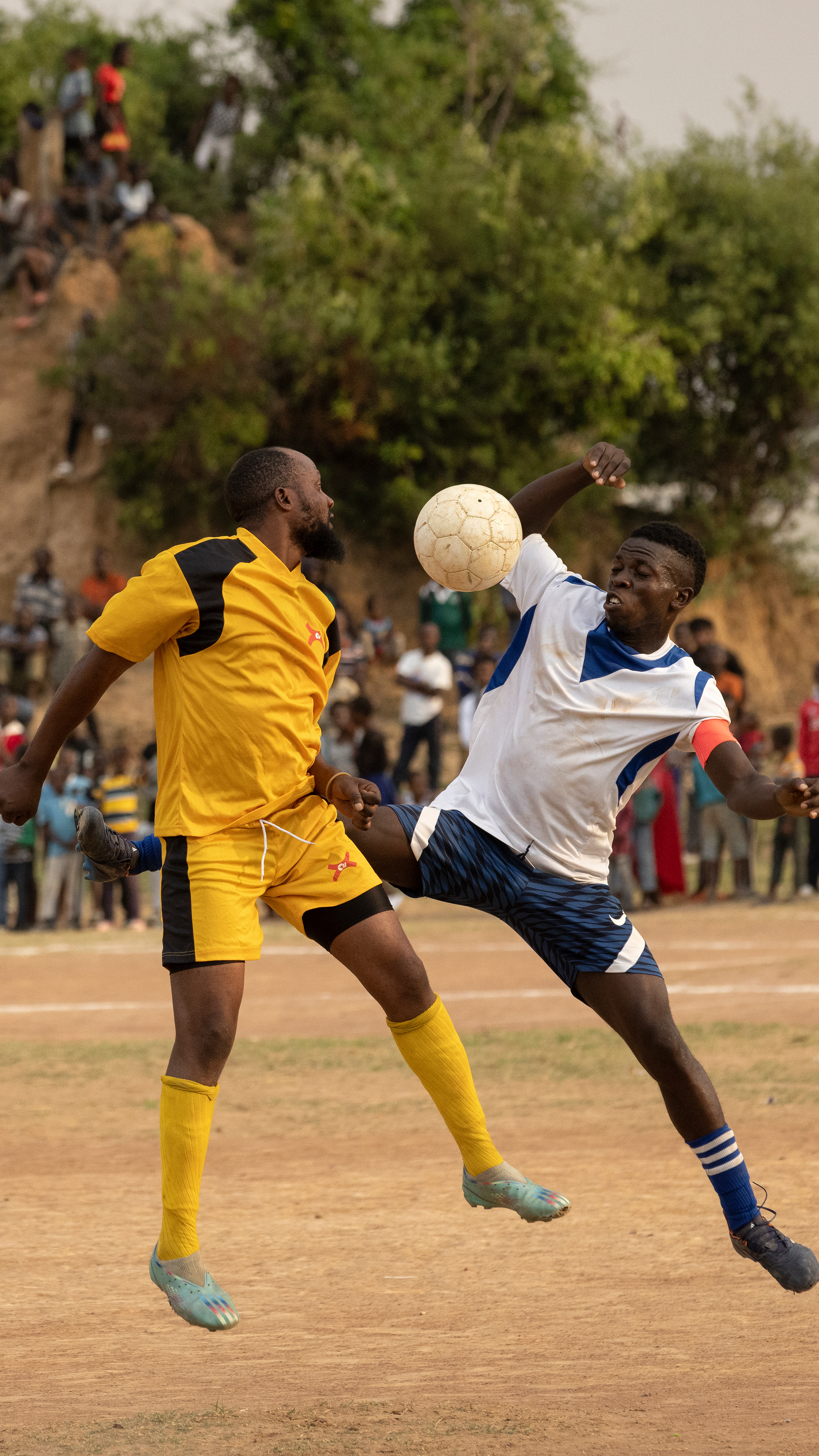 Two football players try and capture the ball during a match