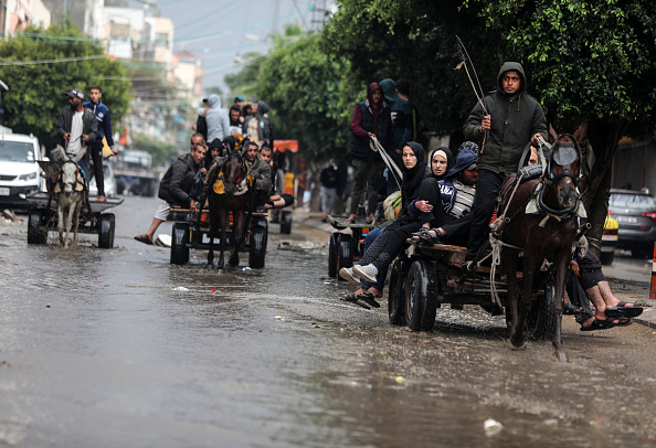 Palestinians are riding horse-drawn carriages in Deir El-Balah, in the central Gaza Strip, on December 12, 2023, following torrential rains, amid continuing battles between Israel and the Palestinian militant group Hamas.