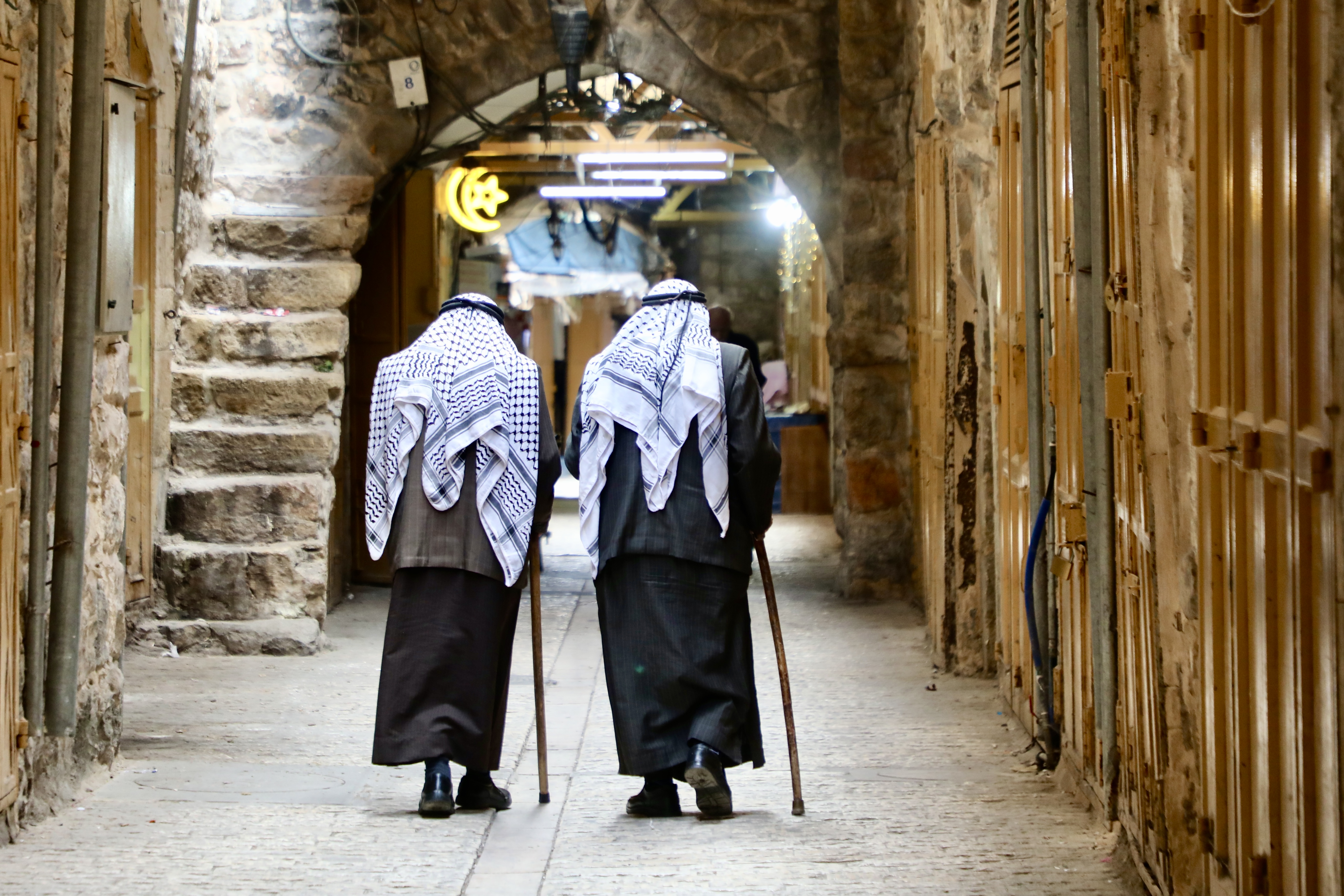 Two elderly men wearing keffiyehs in hebron's Old City
